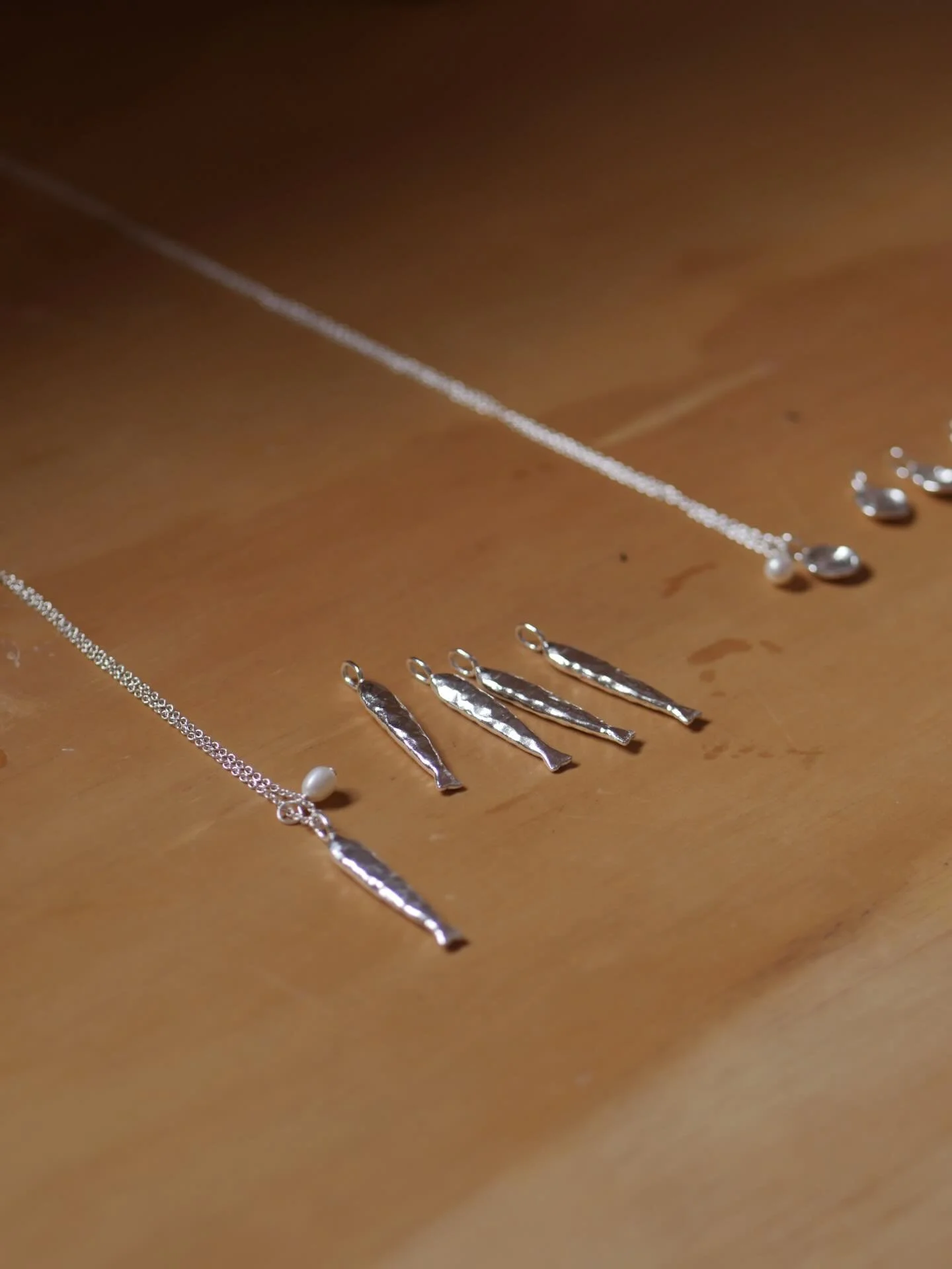 Poseidon necklaces lined up on the bench 🐟