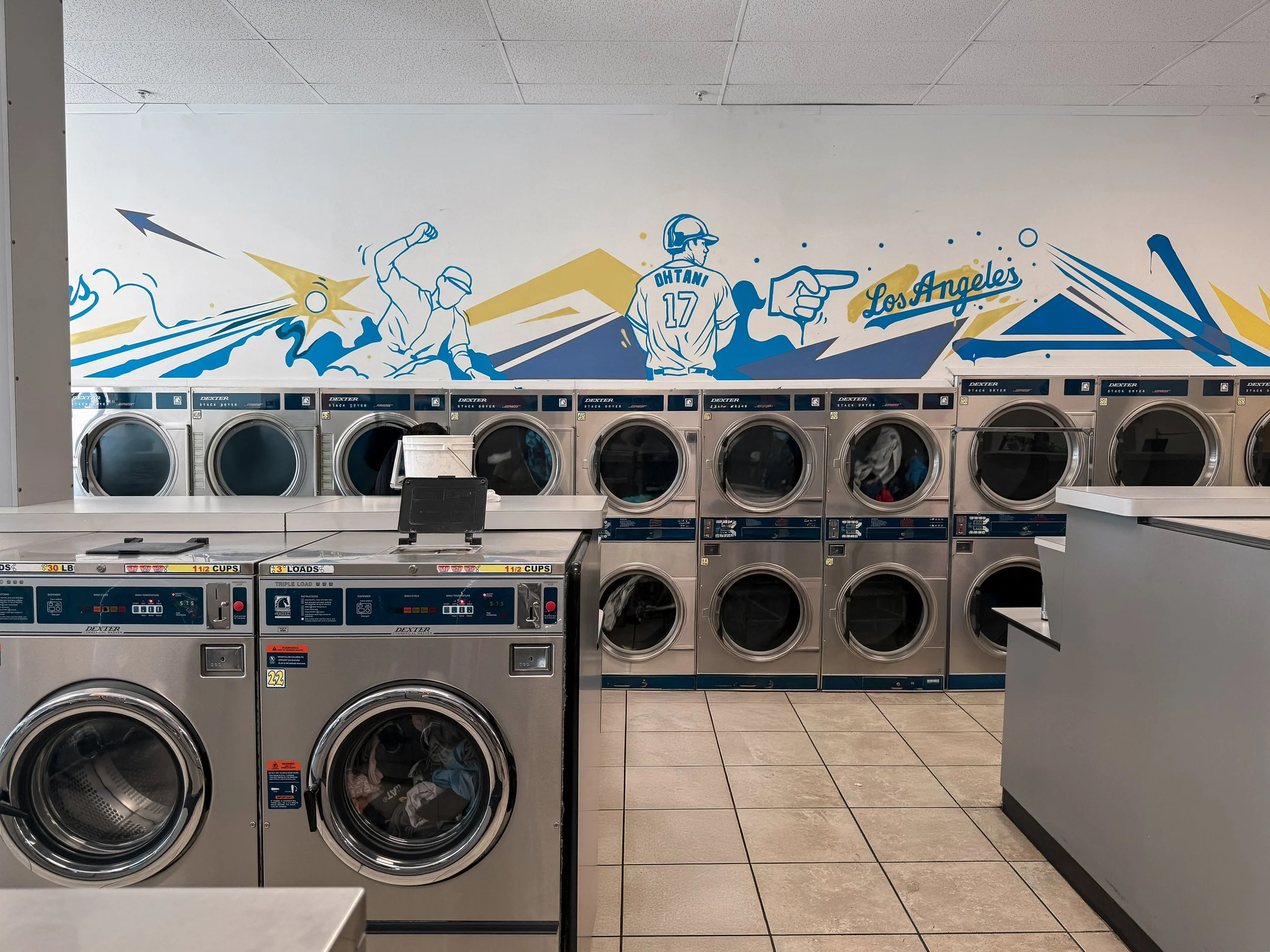 Custom Lakers and Dodgers sports mural painted for laundromat in Los Angeles by mural artist Pezer97 2025