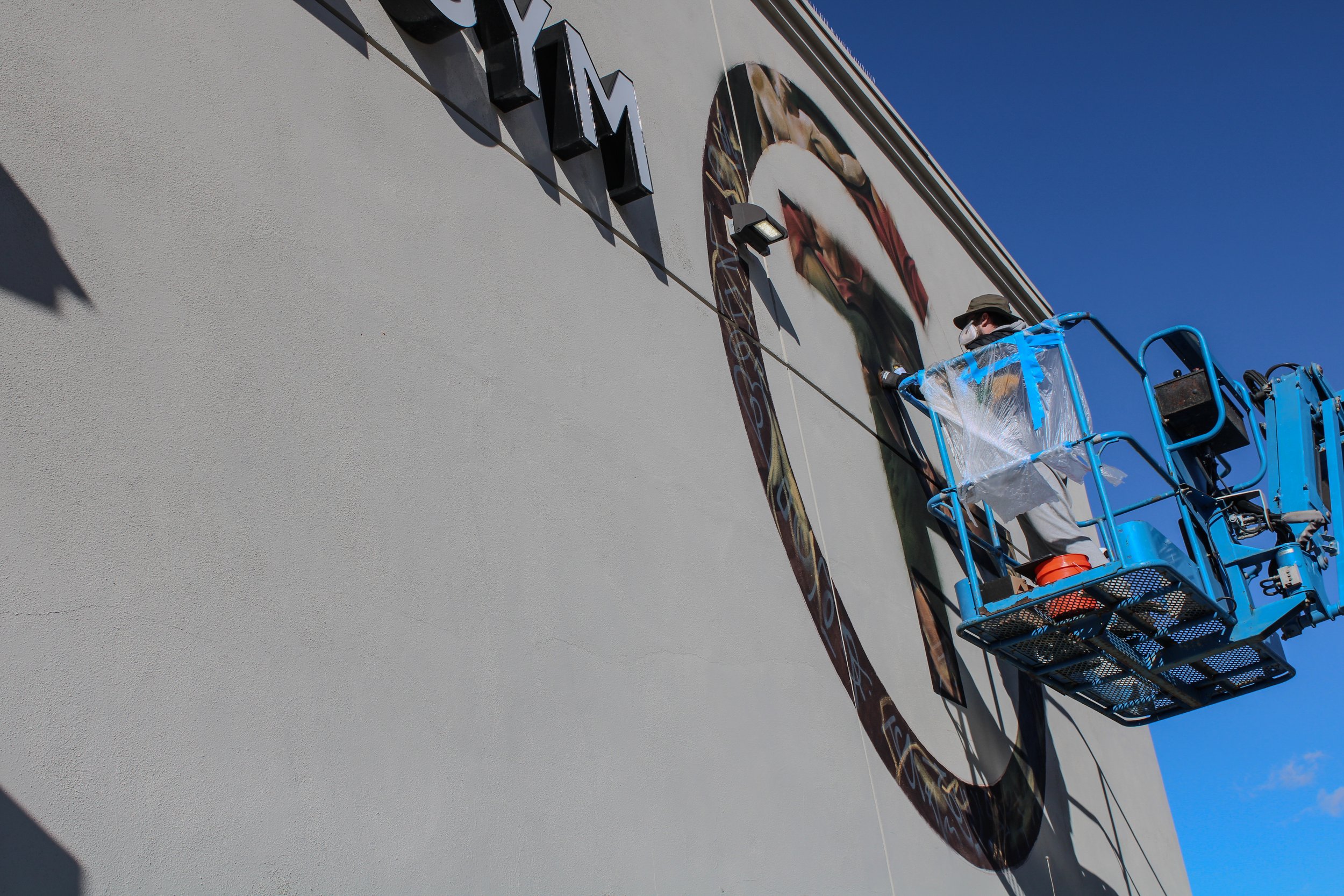 Figurative mural detail of woman painted on exterior wall of The Gym Southern California by Pezer97