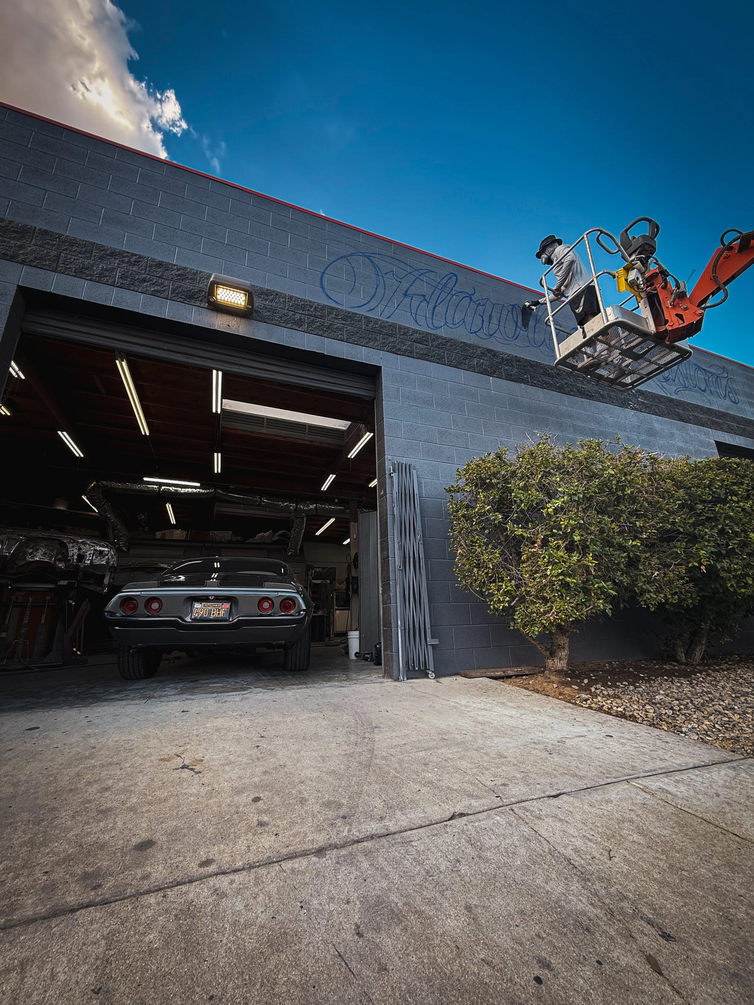 Large-scale exterior graffiti mural painted for Flawless Kustoms automotive garage in Riverside California by Pezer97 2025
