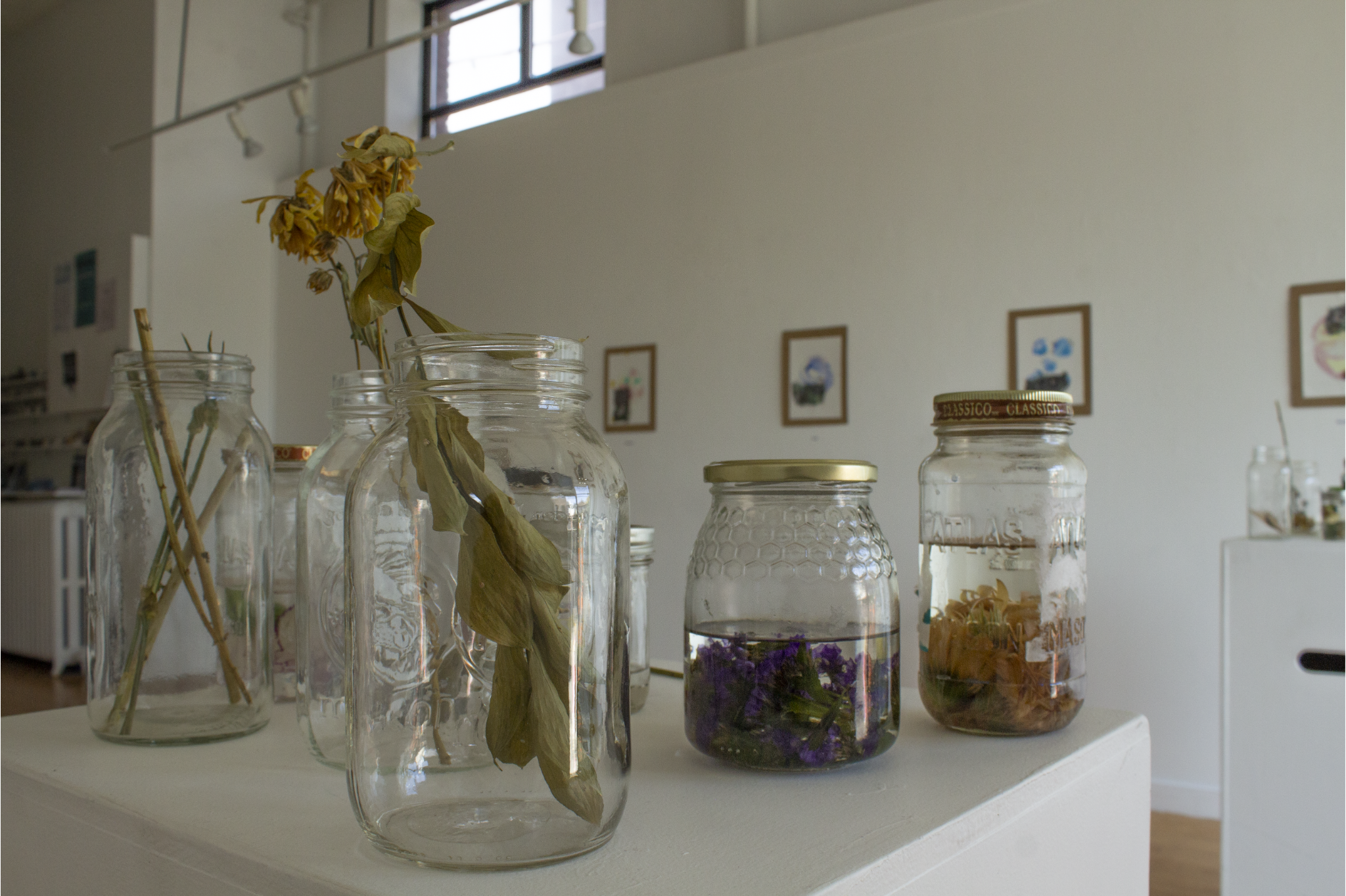 Mason jars filled with flowers on white pedastal