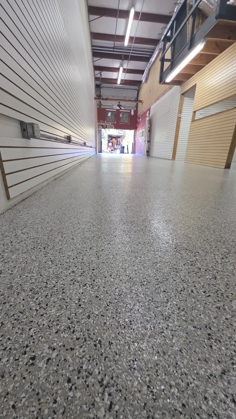 Commercial space with a gray decorative flake floor coating along a long corridor