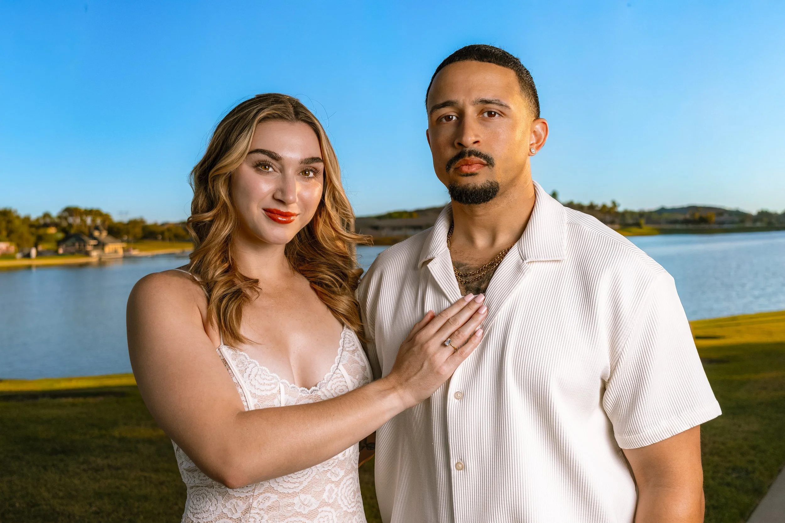 Phoenix engagement photographer capturing couple walking by lake in Scottsdale Arizona with ring detail and natural light