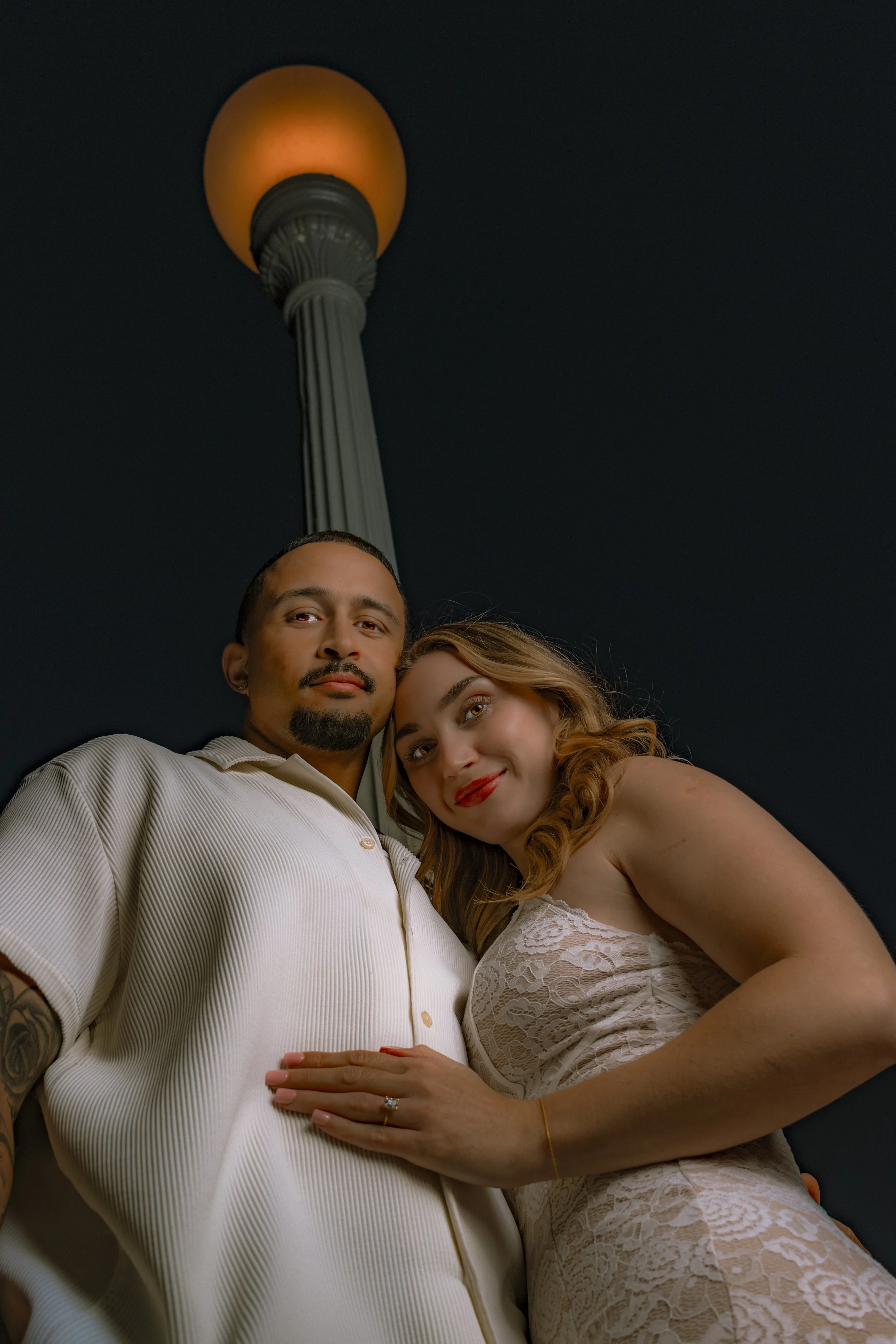Scottsdale engagement photo of couple under streetlight at night, captured by Phoenix engagement photographer BNelly Photography with low-angle composition and dramatic lighting
