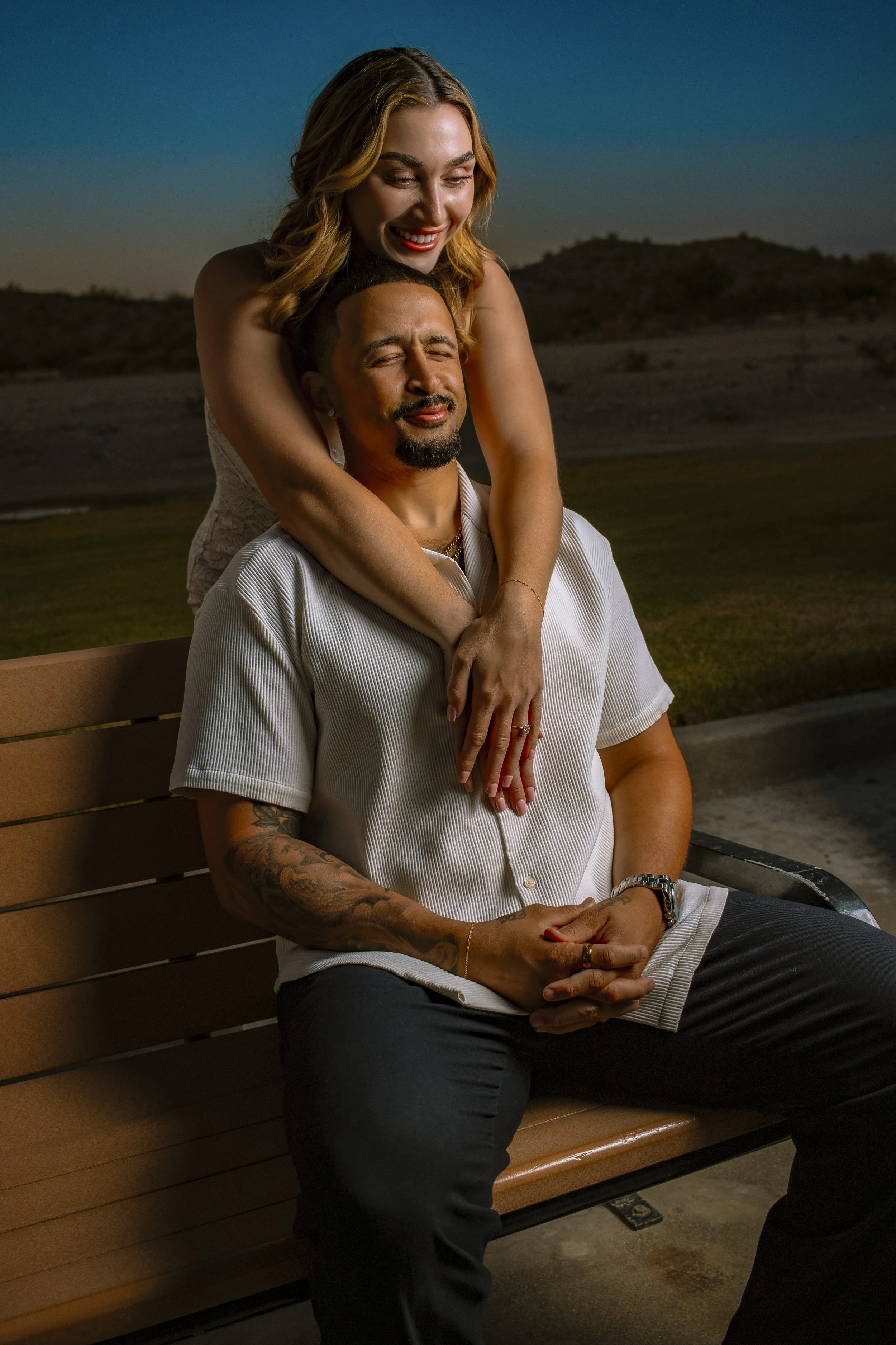 Scottsdale engagement photo of couple sitting on bench at sunset, captured by Phoenix engagement photographer BNelly Photography with natural light and intimate composition