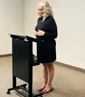 Lisa Assetta speaking at a podium during a speaking engagement