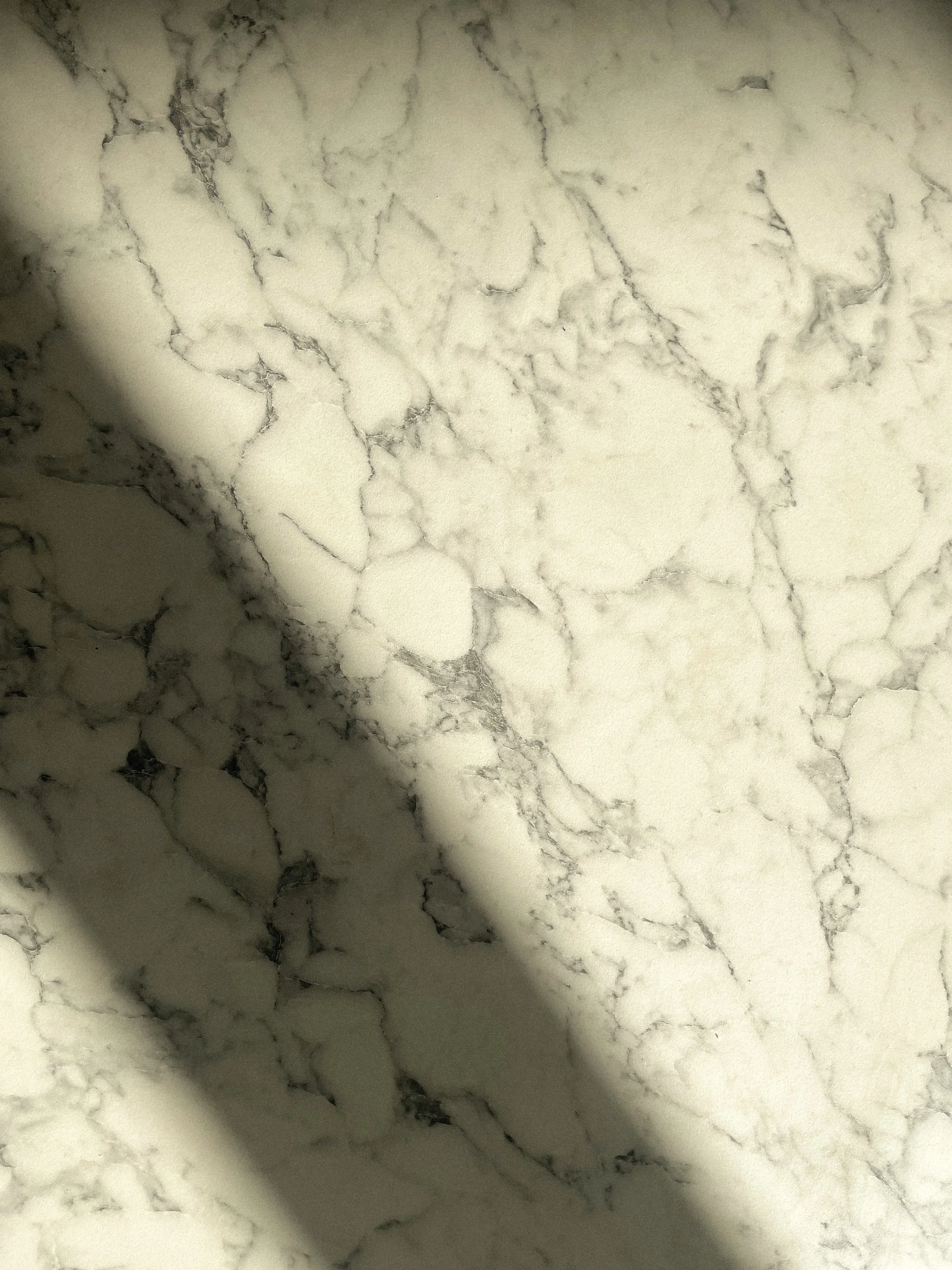 Close-up of a white marble surface with gray veining and shadows.Residential interior design project in Scotland - Interior Designer Scotland - Interiors 