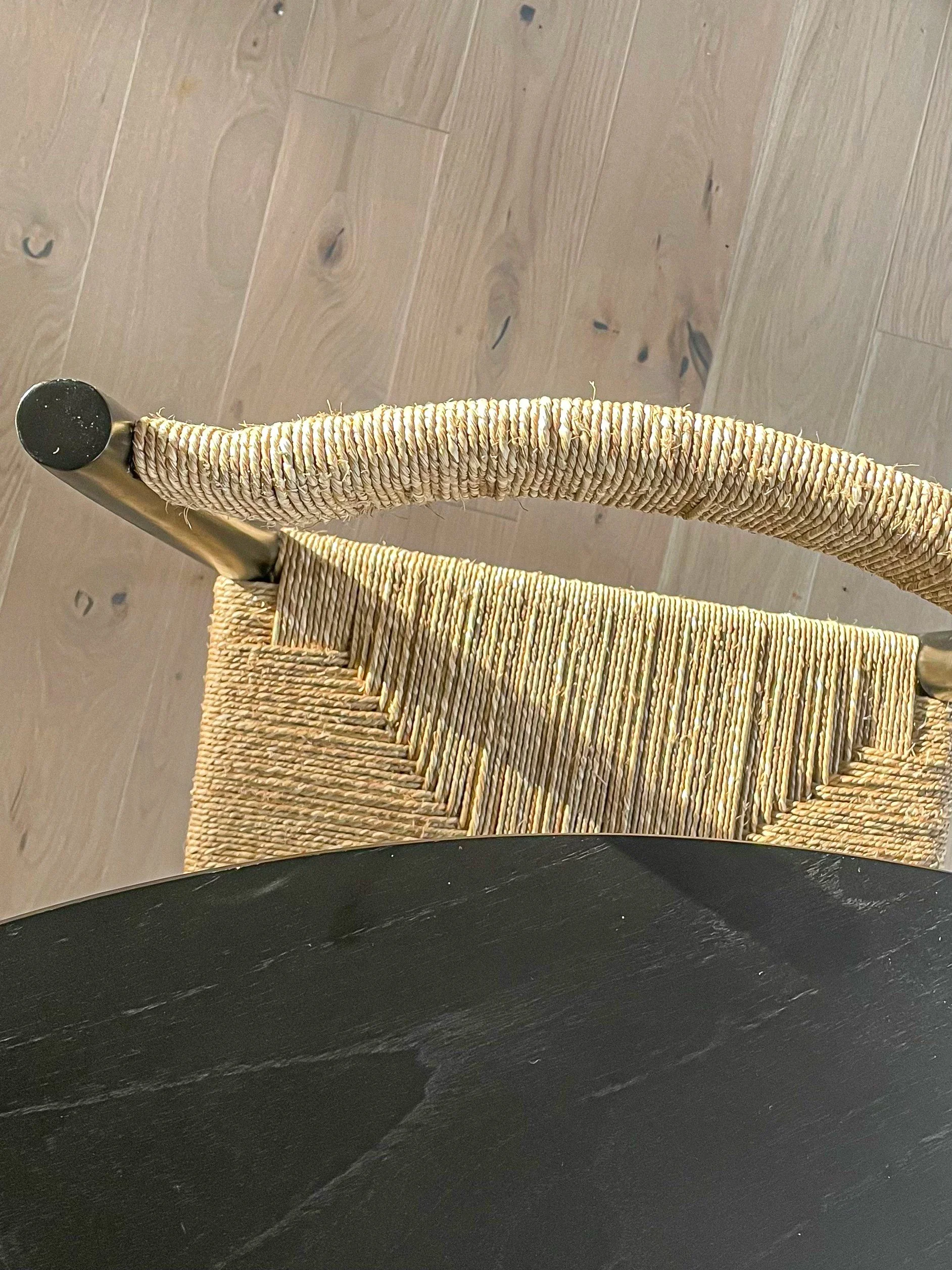 Top-down view of a woven chair with a black wooden table in the foreground and a light wood flooring background.Residential interior design project in Scotland - Interior Designer Scotland - Interiors 