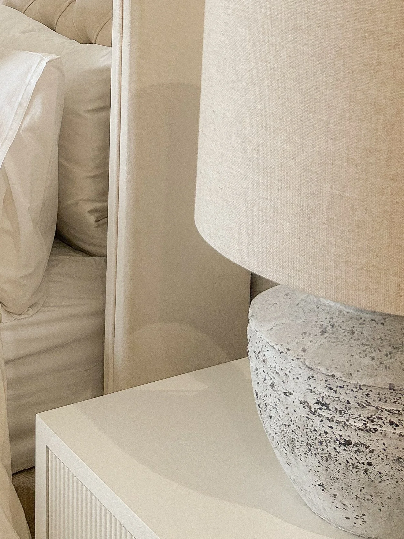 Close-up of a textured white lamp on a white bedside table, with a beige headboard and bed linens in the background.“Residential interior design project in Scotland by [Studio Name], working across Glasgow, Edinburgh, Dundee and the Highlands.”

“Con