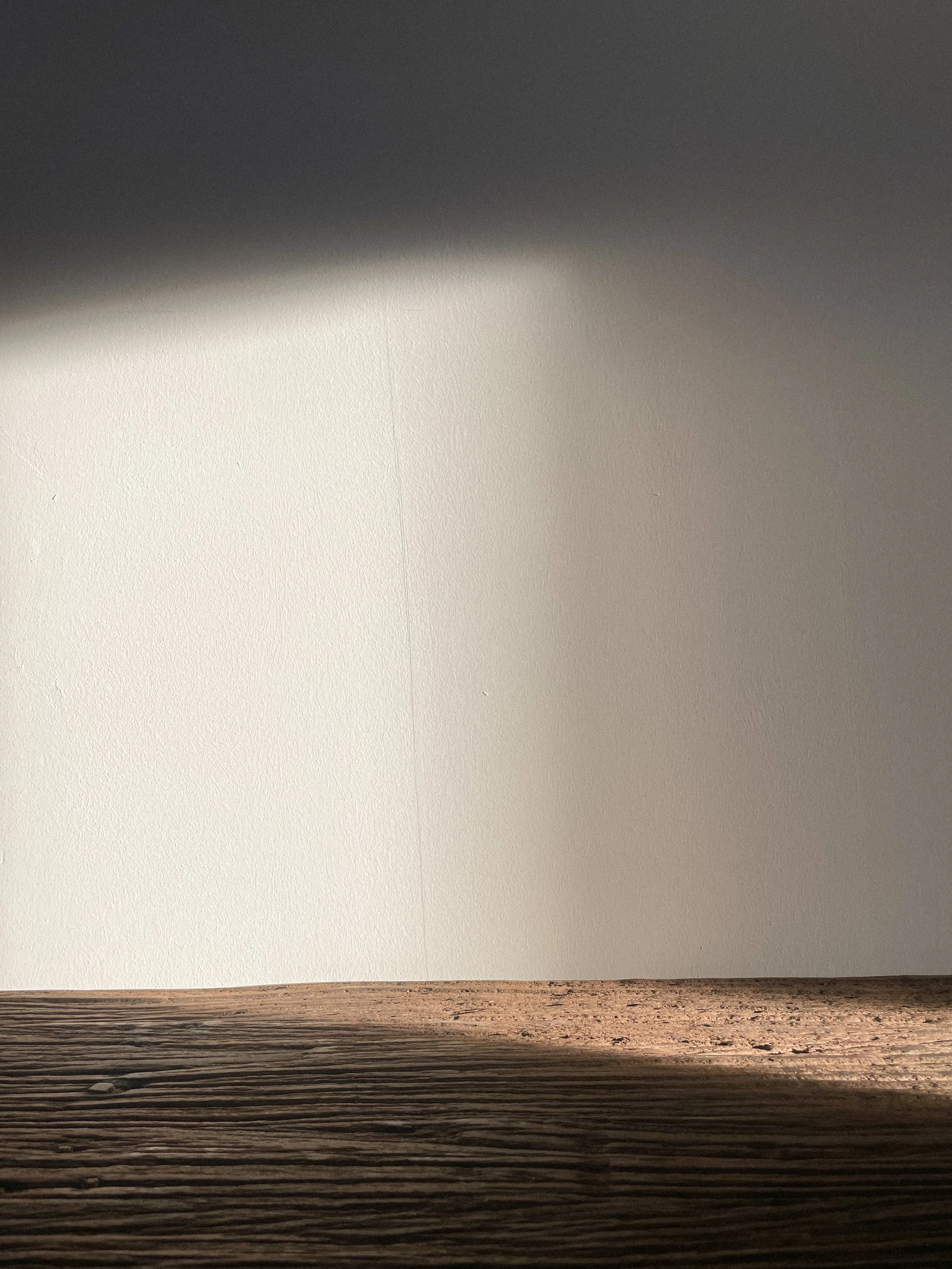 A close-up photo of a wooden surface with light and shadows, and a plain light-colored wall in the background.Residential interior design project in Scotland - Interior Designer Scotland - Interiors 