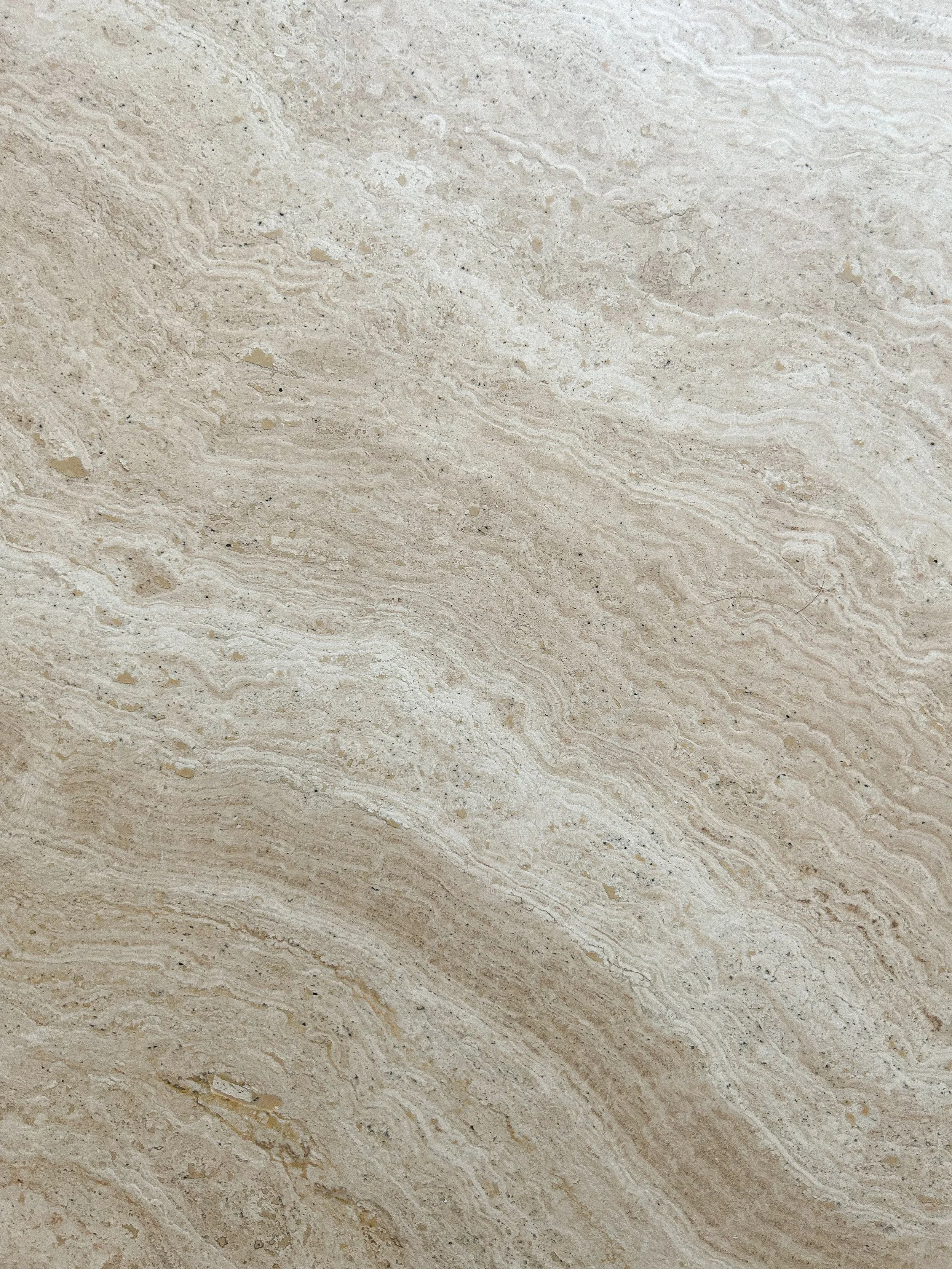 Close-up of a beige, textured stone or marble surface with natural veining patterns.Residential interior design project in Scotland - Interior Designer Scotland - Interiors 