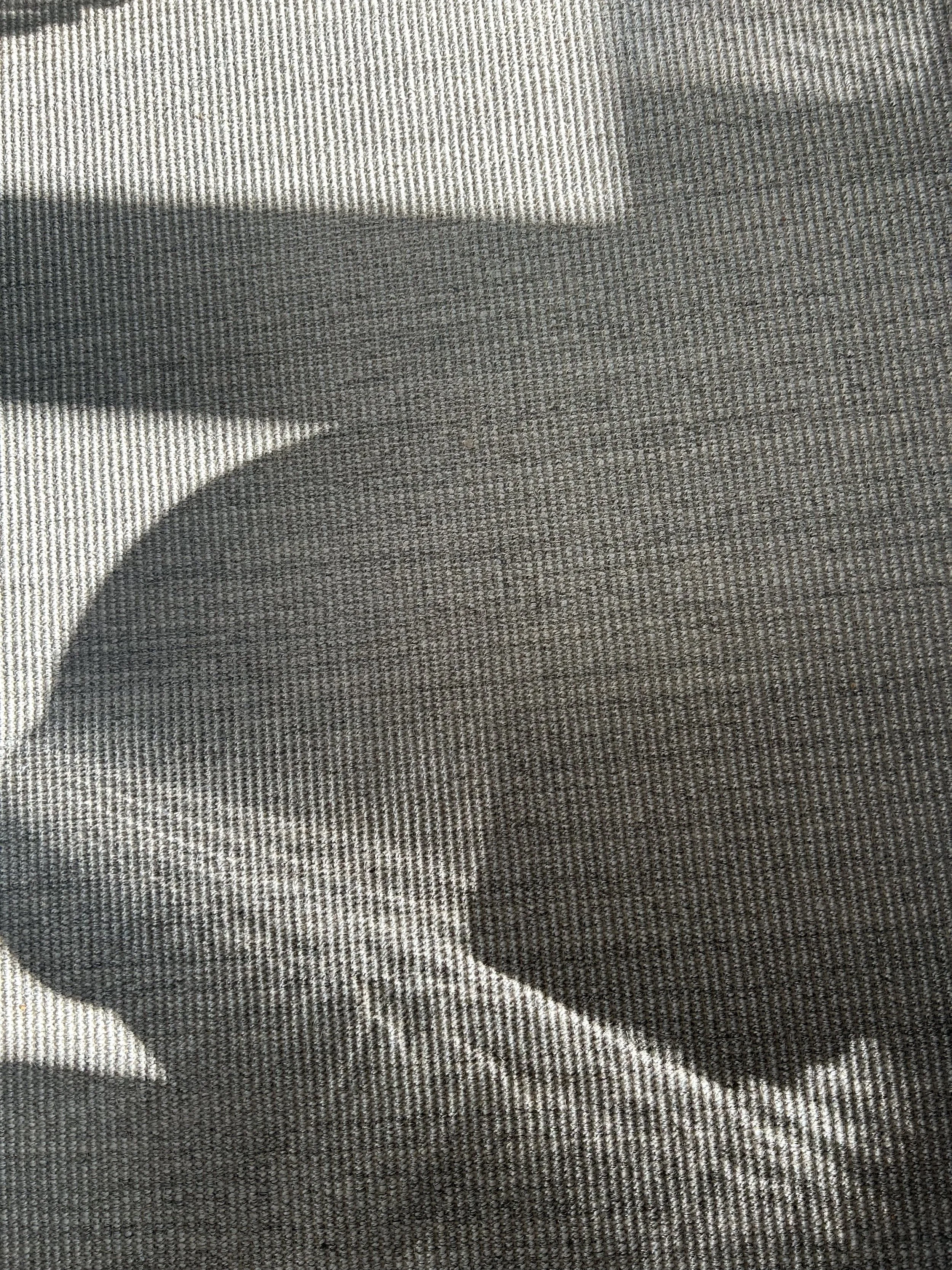 Close-up of a person’s hand resting on a textured fabric surface, with the shadow of the hand visible.Residential interior design project in Scotland - Interior Designer Scotland - Interiors 