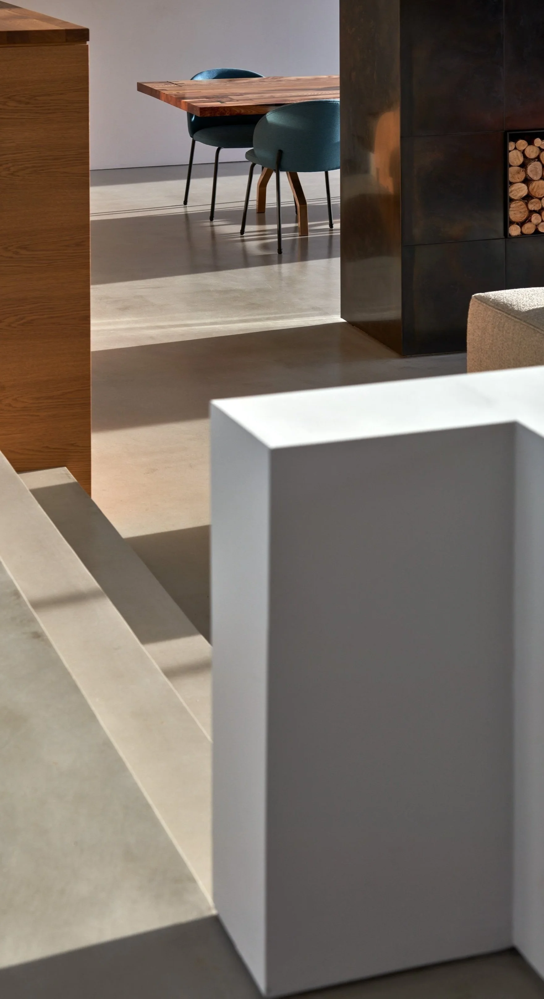 A modern interior with wooden furniture, including a table and blue green chairs, a black storage unit with firewood, and white and gray decorative elements.“Residential interior design project in Scotland by [Studio Name], working across Glasgow, Ed