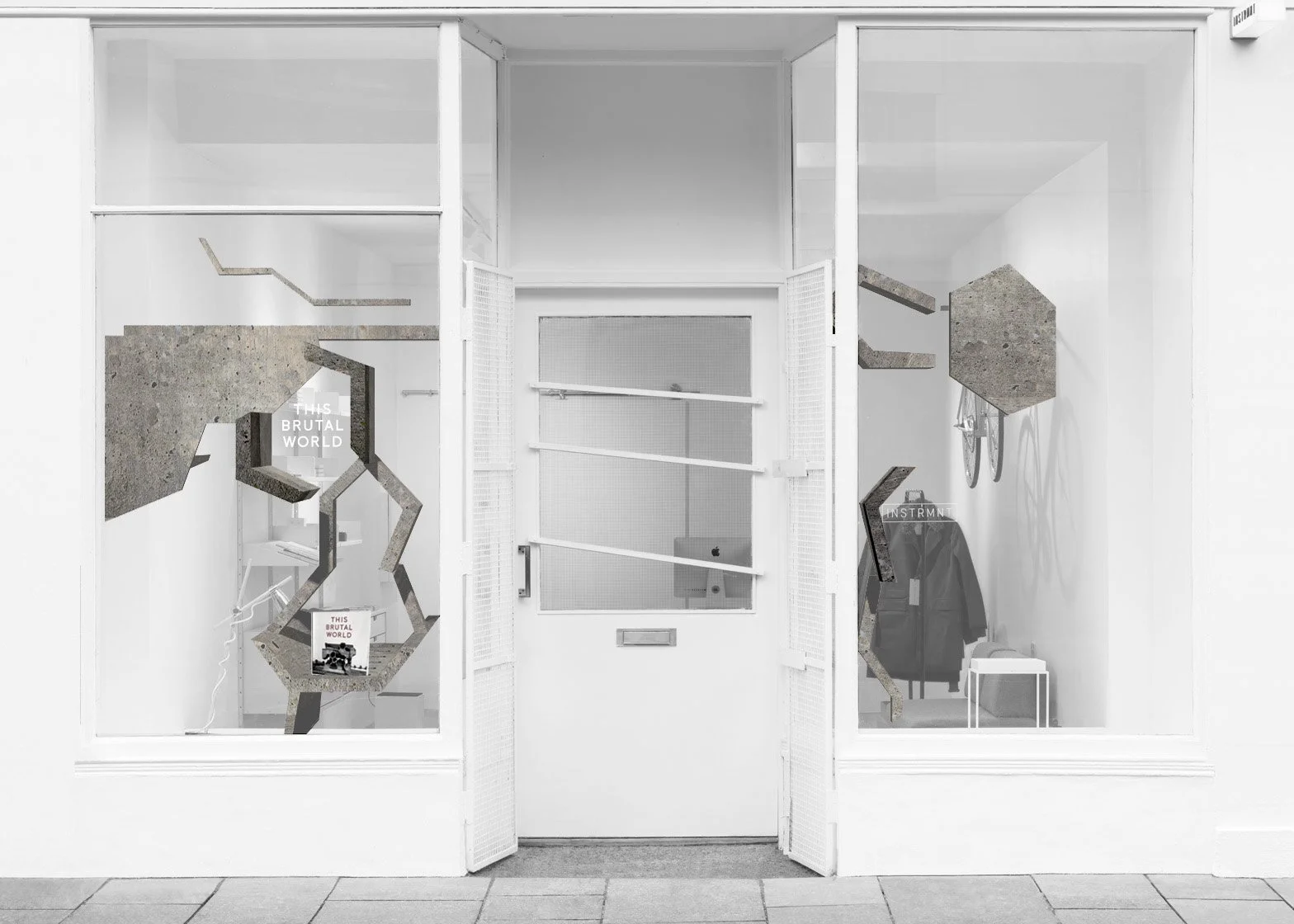 View through the glass window and door of a modern minimalist art installation inside a gallery, featuring geometric concrete structures and words like 'This Brutal World' and 'Instrument' on display.Residential interior design project in Scotland - 