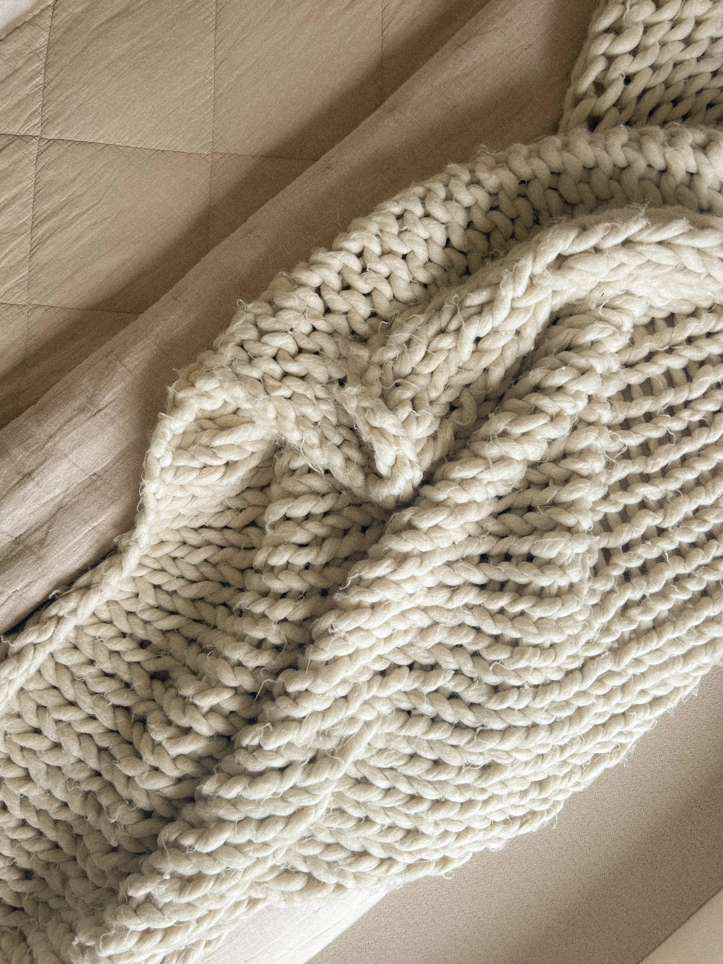 Close-up of a cream-colored chunky knit blanket or throw draped over a beige surface.“Residential interior design project in Scotland by [Studio Name], working across Glasgow, Edinburgh, Dundee and the Highlands.”

“Contemporary Scottish interior des