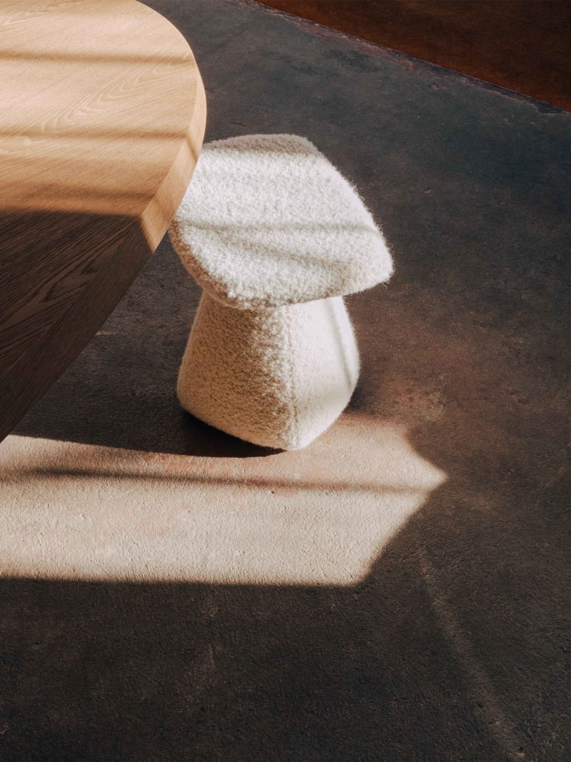 A plush mushroom-shaped stool under a wooden table on a beige rug, with a shadow cast on the dark floor.“Residential interior design project in Scotland by [Studio Name], working across Glasgow, Edinburgh, Dundee and the Highlands.”

“Contemporary Sc