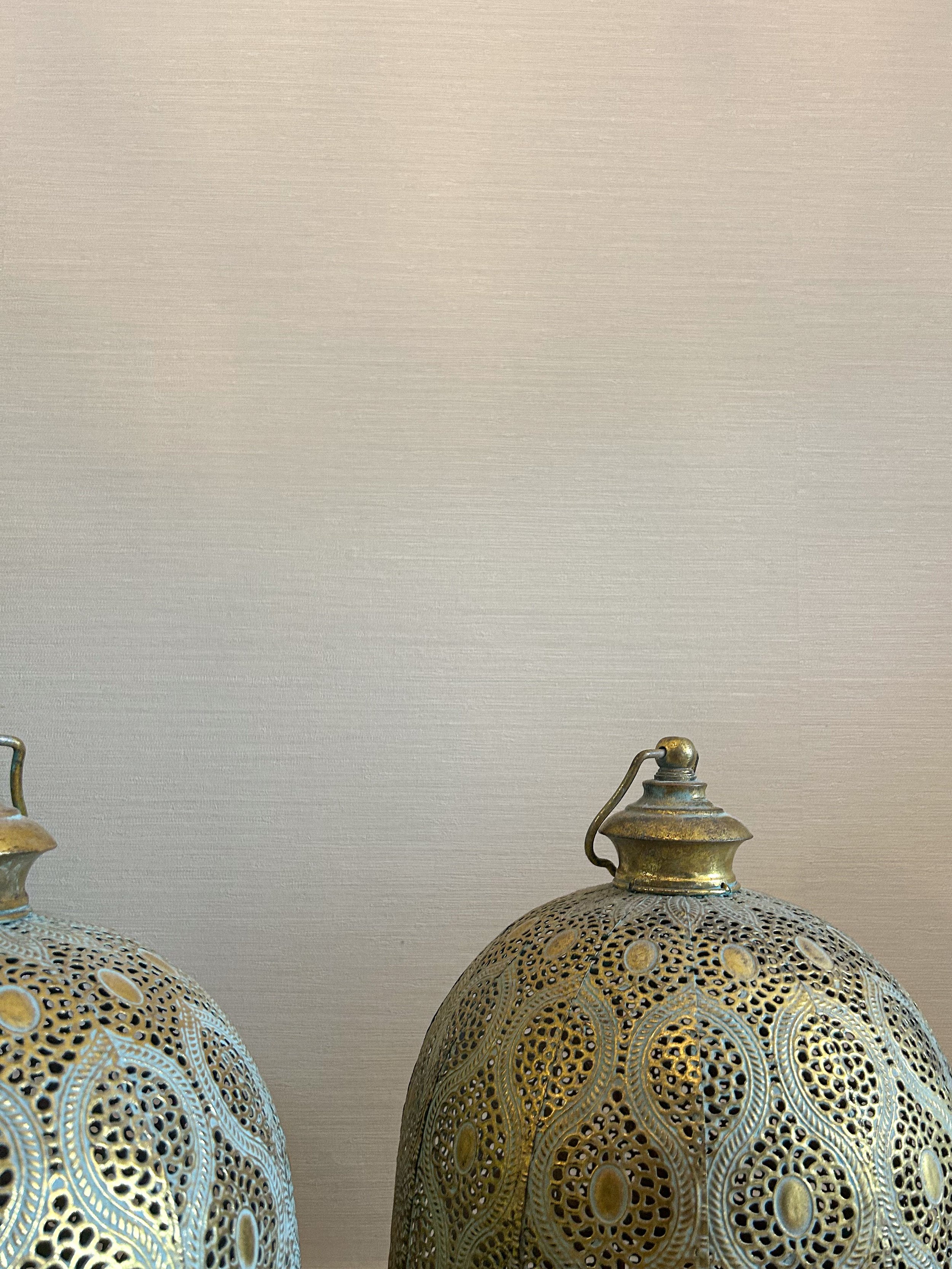 Two ornate metallic hanging pendant lights with intricate perforations and patterns, hanging against a plain beige wall.Residential interior design project in Scotland - Interior Designer Scotland - Interiors 