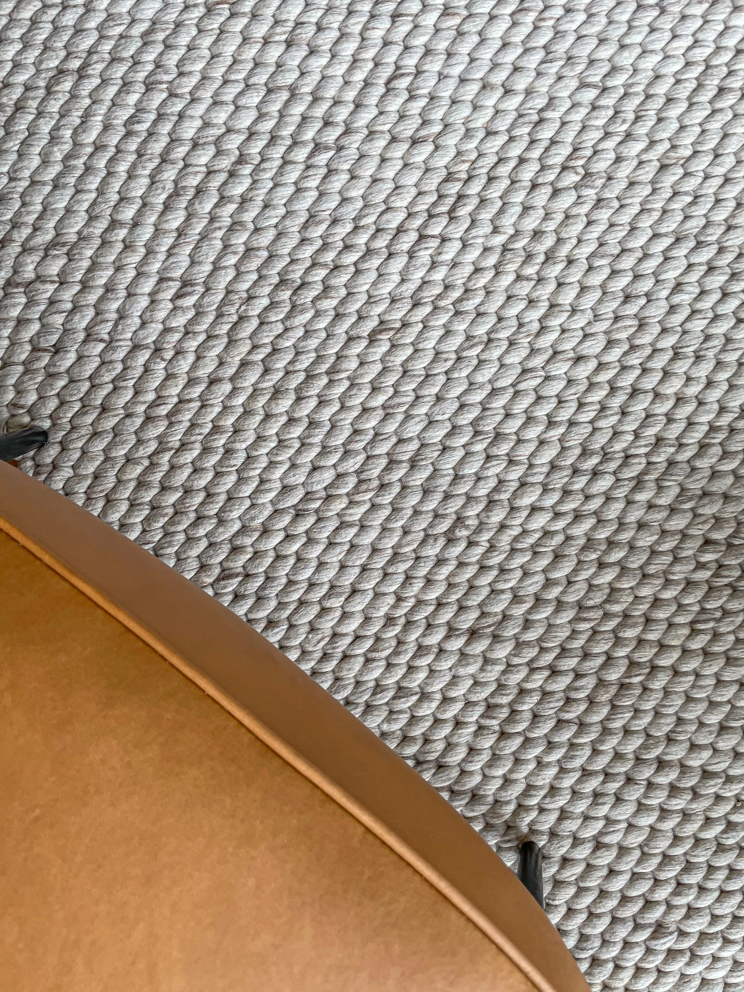 Close-up of a textured woven rug with a partial view of a brown leather chair leg and a person's shoe.“Residential interior design project in Scotland by [Studio Name], working across Glasgow, Edinburgh, Dundee and the Highlands.”

“Contemporary Scot