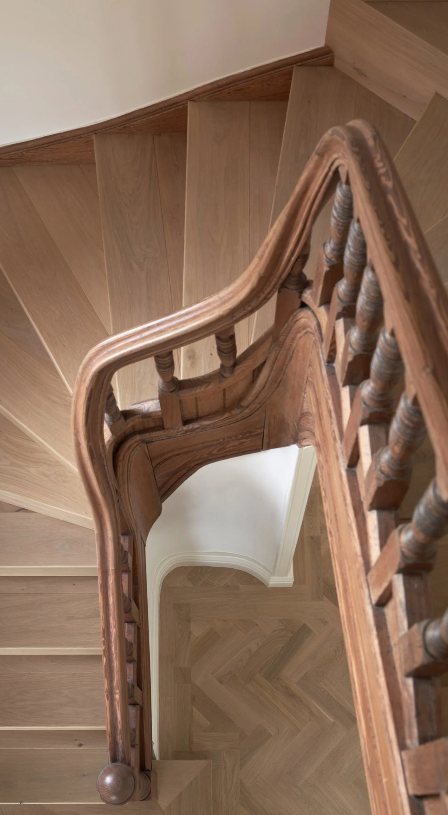 Top-down view of a wooden staircase with a curved handrail, showing the staircase's steps and the flooring below.“Residential interior design project in Scotland by [Studio Name], working across Glasgow, Edinburgh, Dundee and the Highlands.”

“Contem