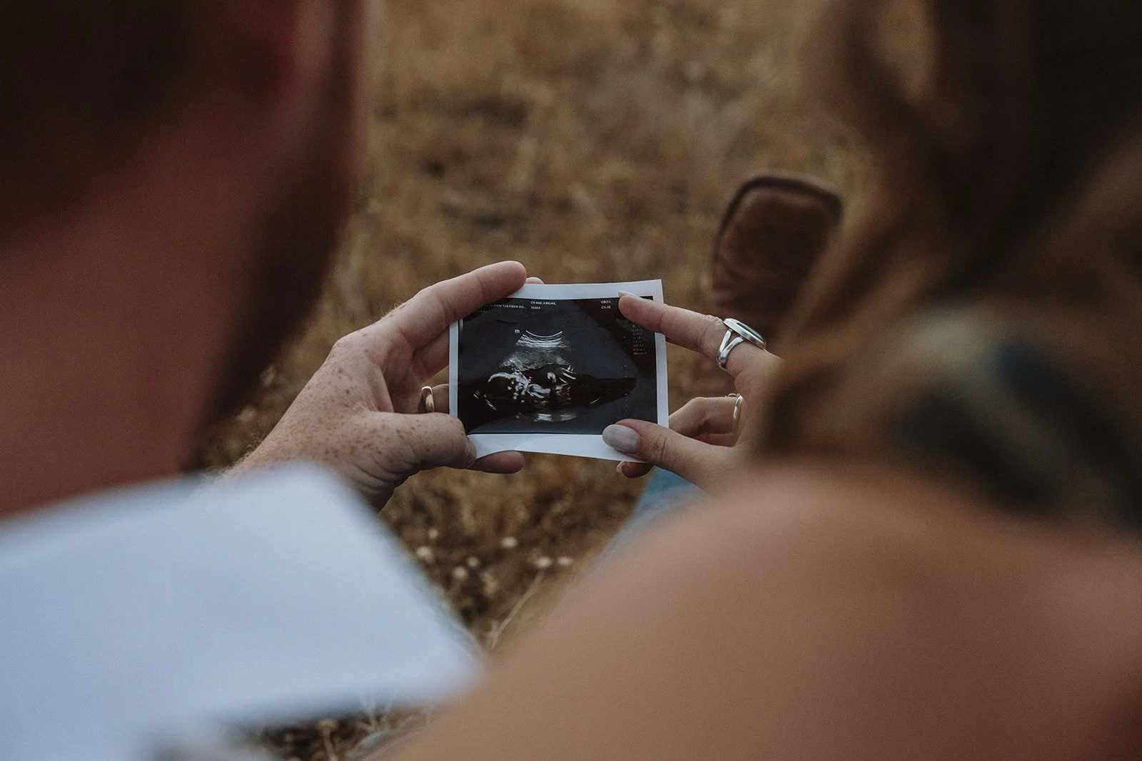 Abby and River holding a sonogram together during their maternity session in Polson, Montana