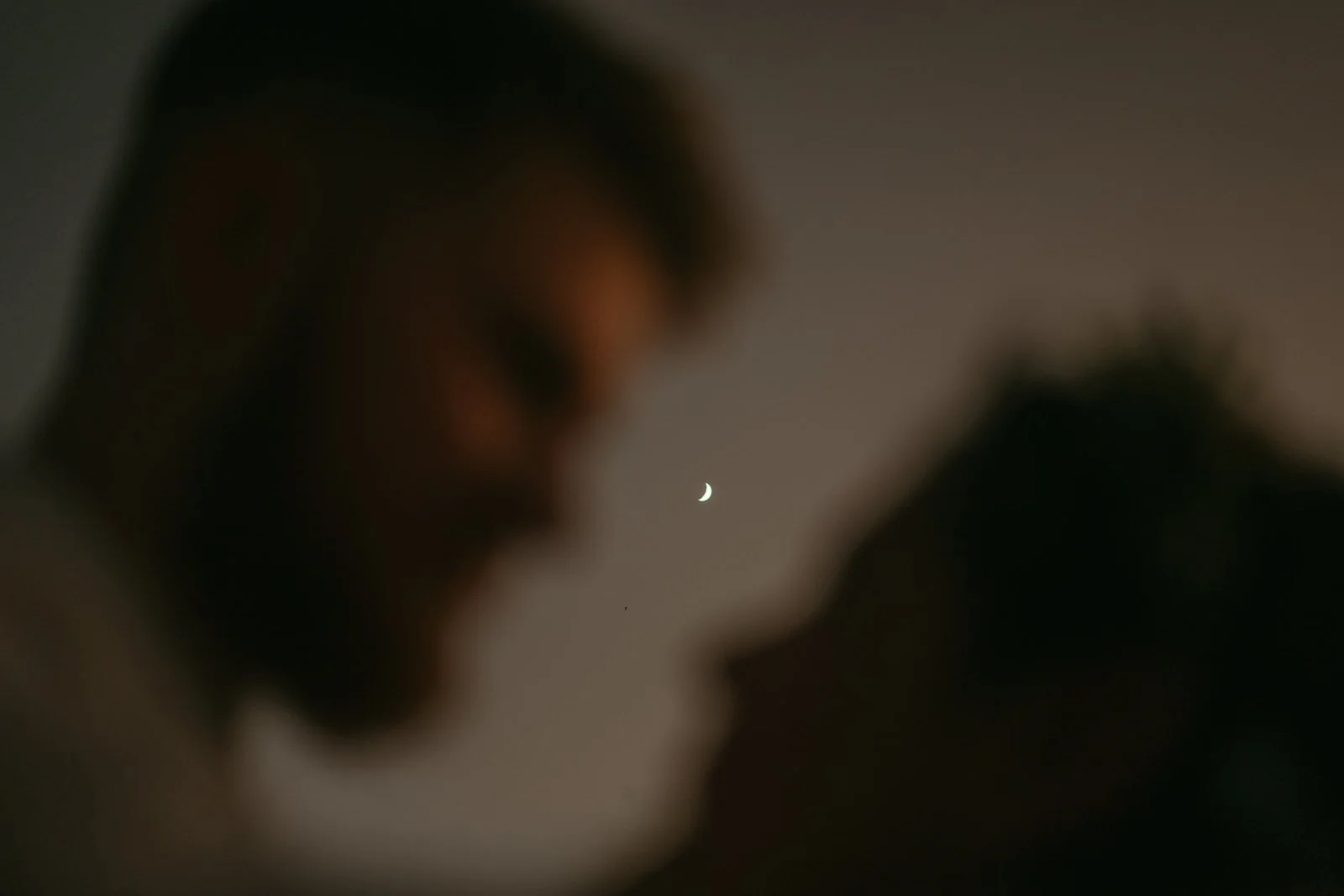 silhouette of a couple’s faces with the moon behind them