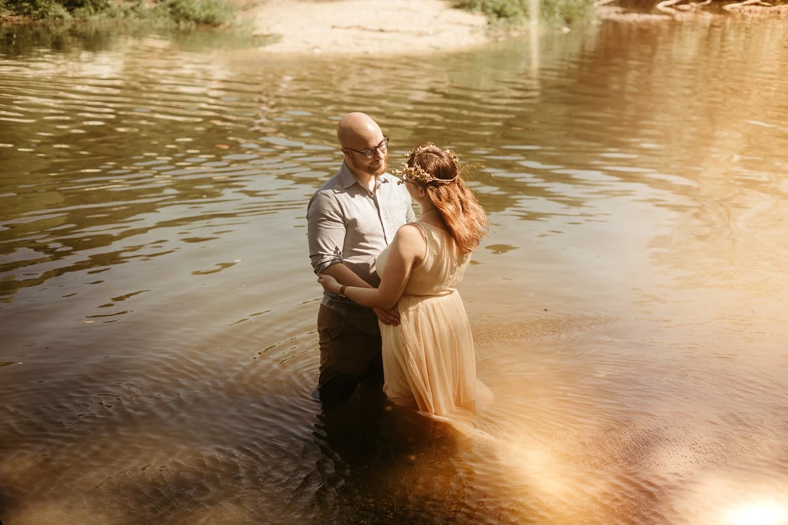 Dan and Carolyn holding each other while standing in a pond along Onion Creek