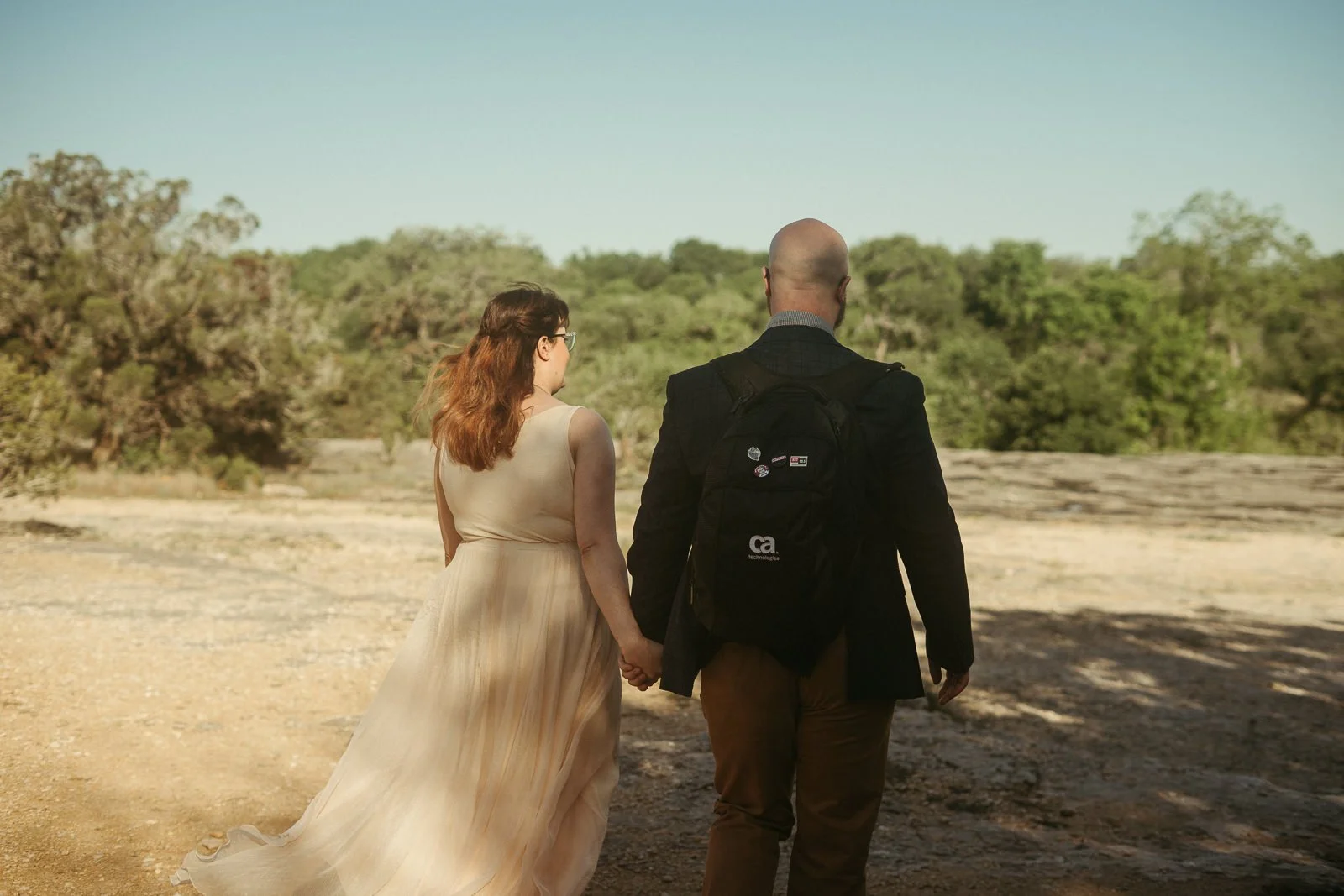 Dan and Carolyn holding hands as they walk away into the trail together