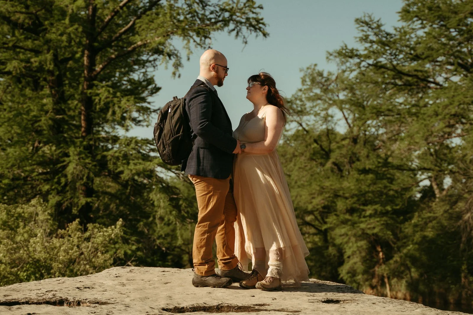 Couple holding each other on a limestone cliff overlooking Onion Creek
