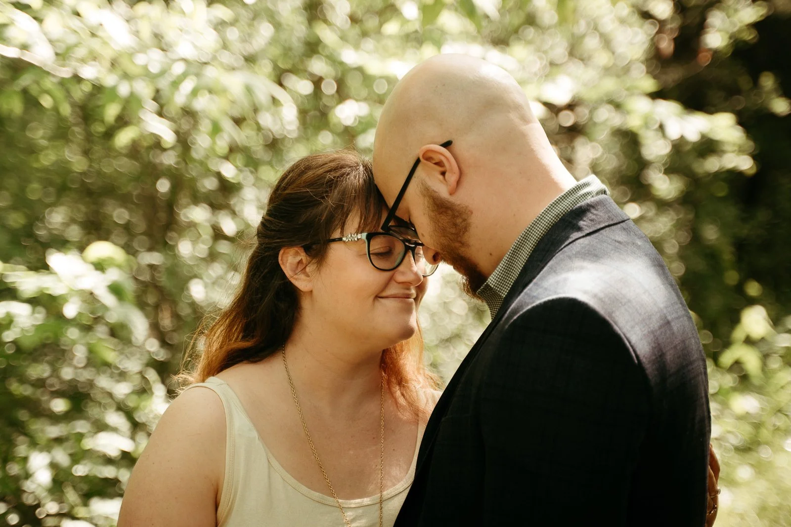 Couple smiling as they hold each other after their ceremony surrounded by trees
