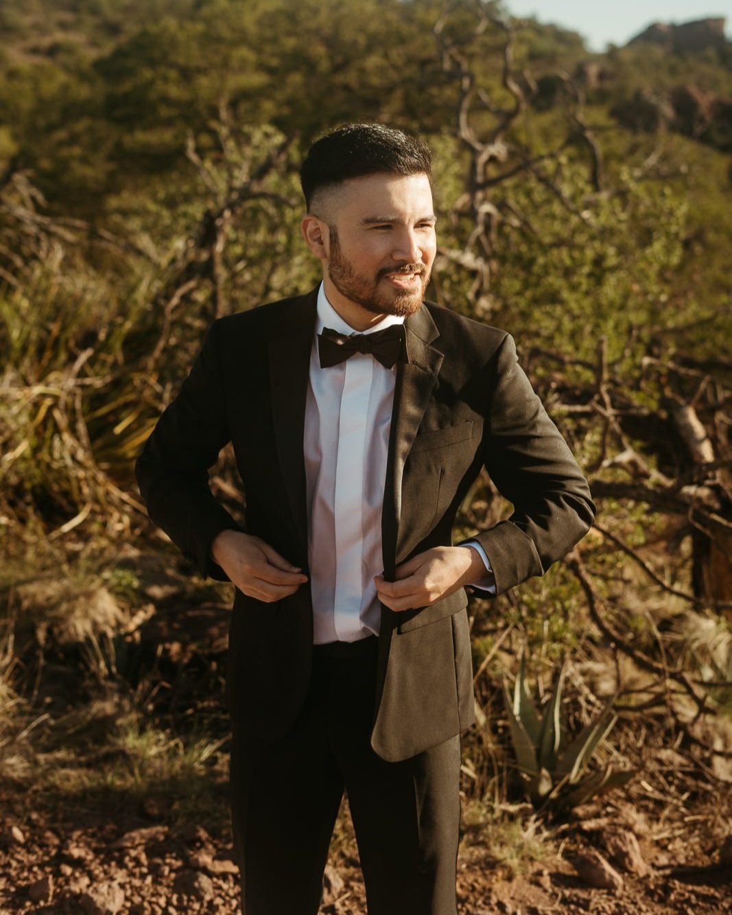 A groom putting on his suit coat while getting ready in Big bend national park