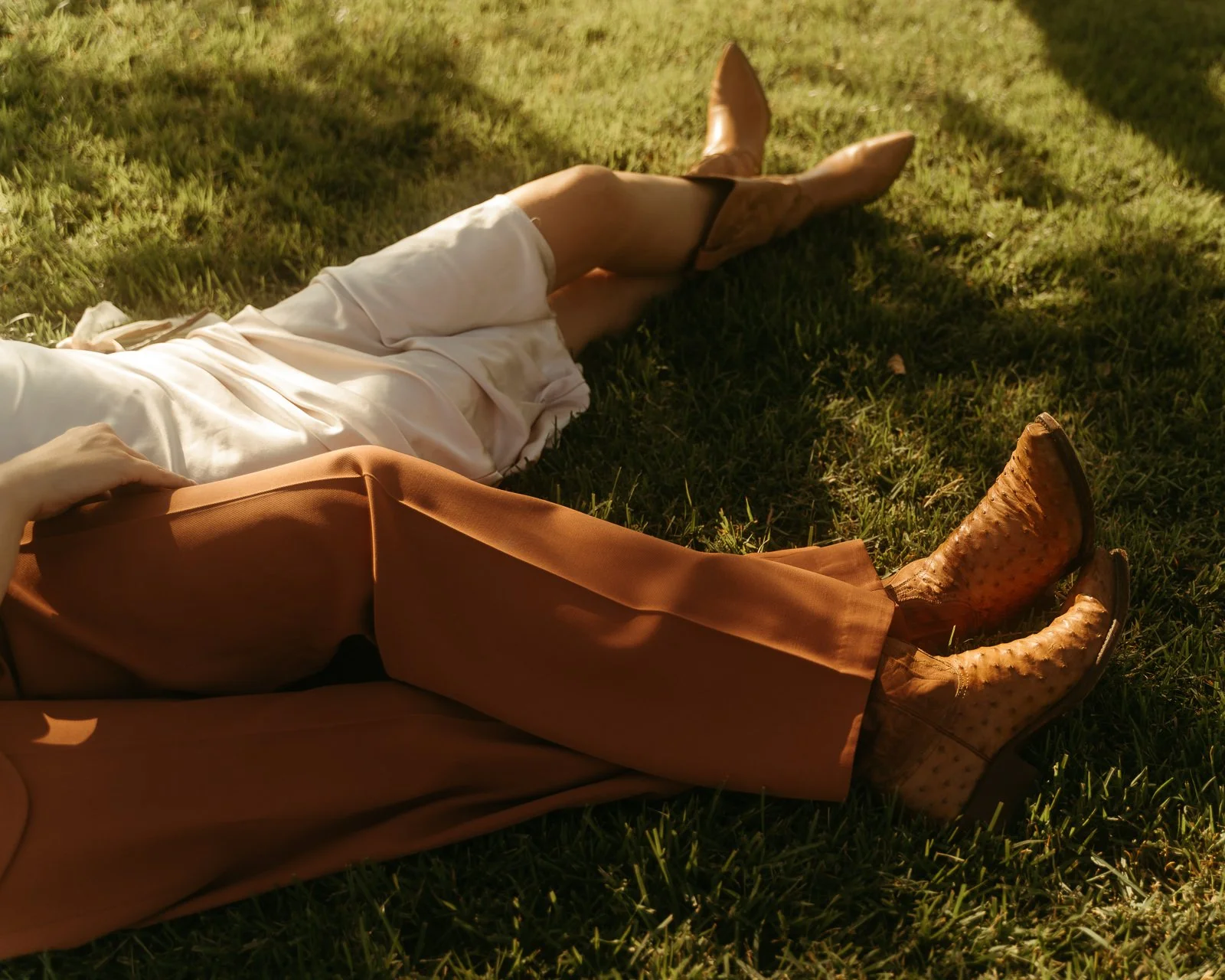 couple sleeping in the grass after their ceremony on a sunny afternoon