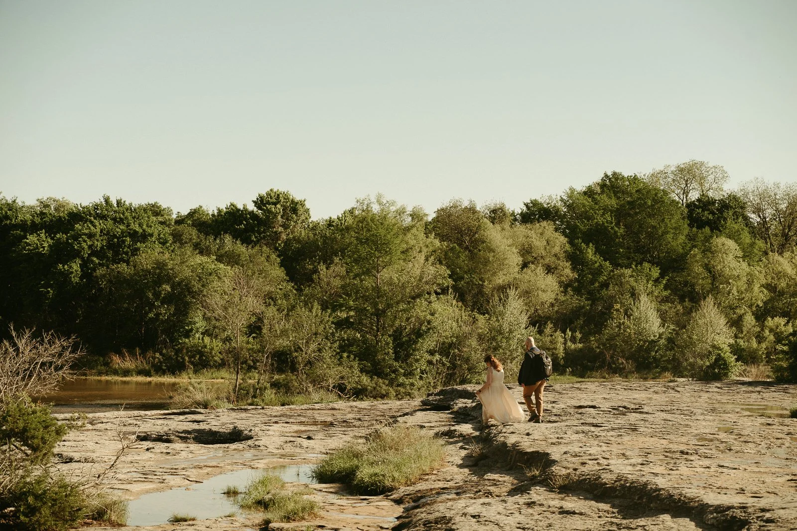 Couple walking away on the limestone at McKinney Falls together