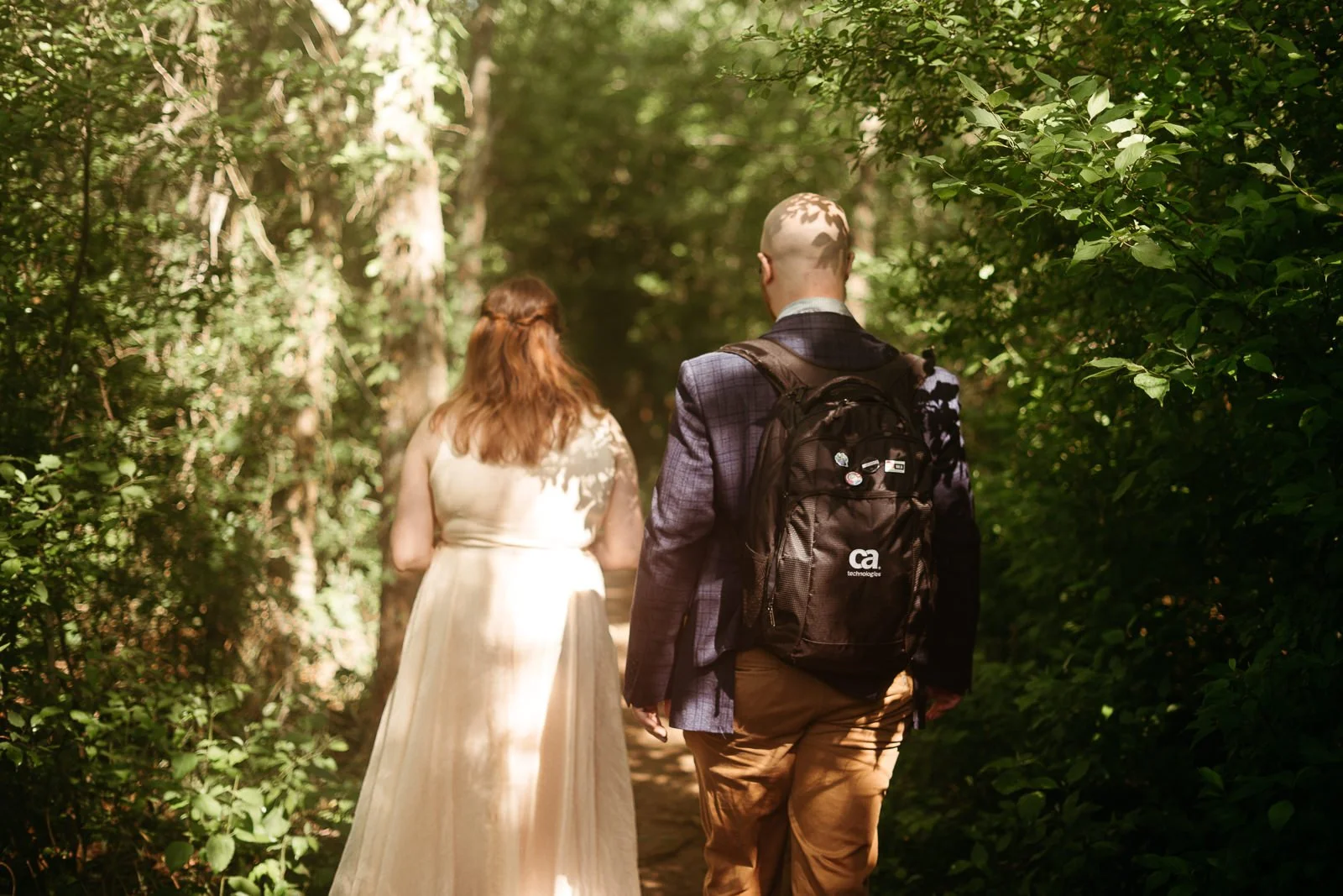 Dan and Carolyn walking into a tree-lined trail together