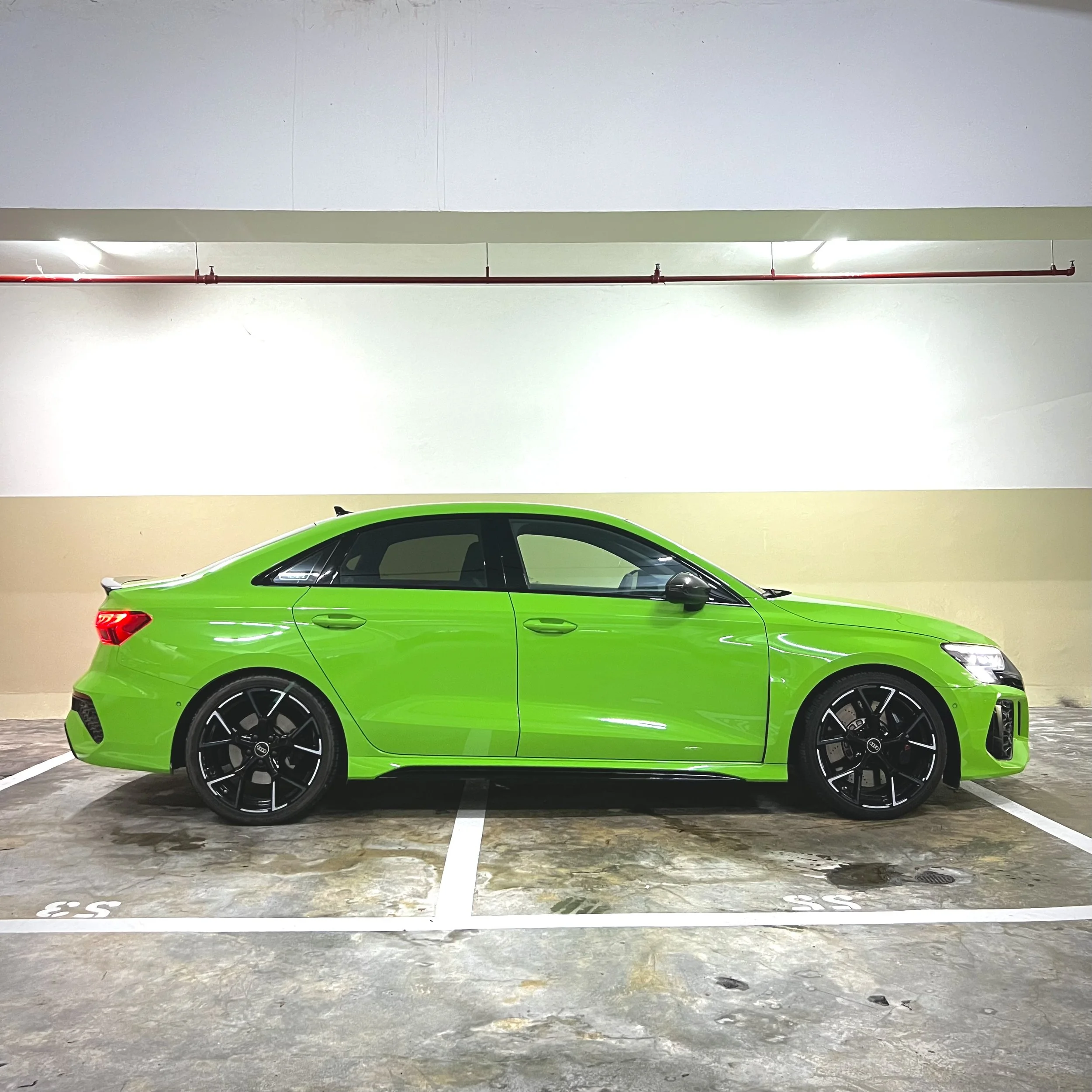 Green sedan car parked in a garage