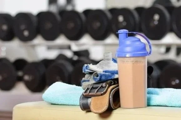 Protein shake beside gym equipment after a workout