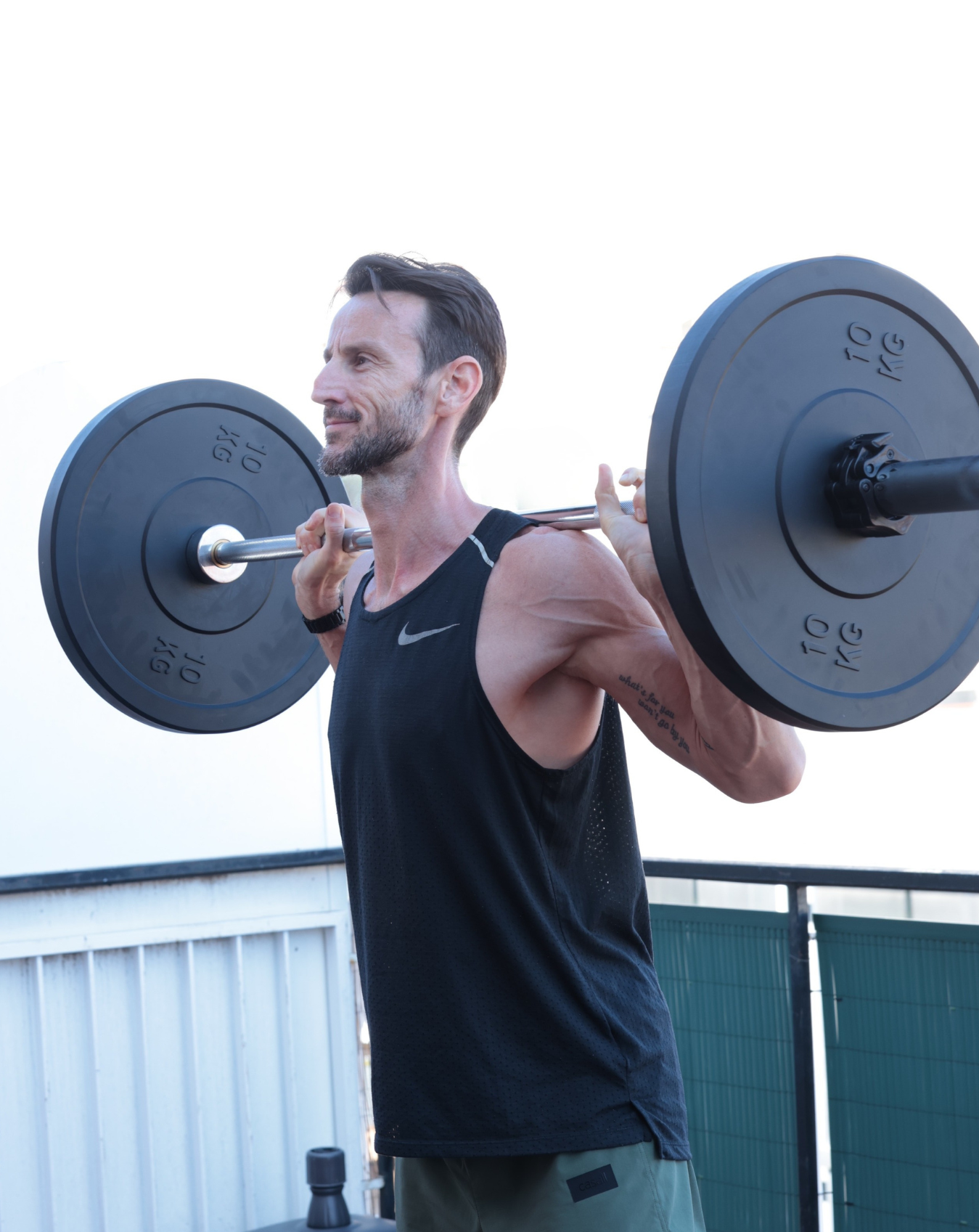 Martin Ebner, personal trainer in Eixample, performing barbell press on his private outdoor terrace in Barcelona