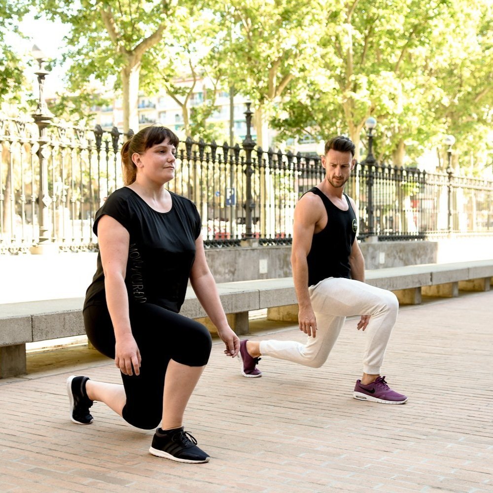 Ebylife trainer guiding a client through lunge exercises in an outdoor park