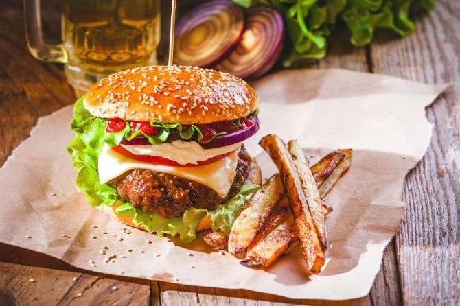 Juicy cheeseburger and fries representing a balanced cheat meal in a diet plan