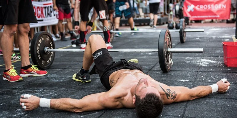 Exhausted athlete lying on the ground after a CrossFit competition
