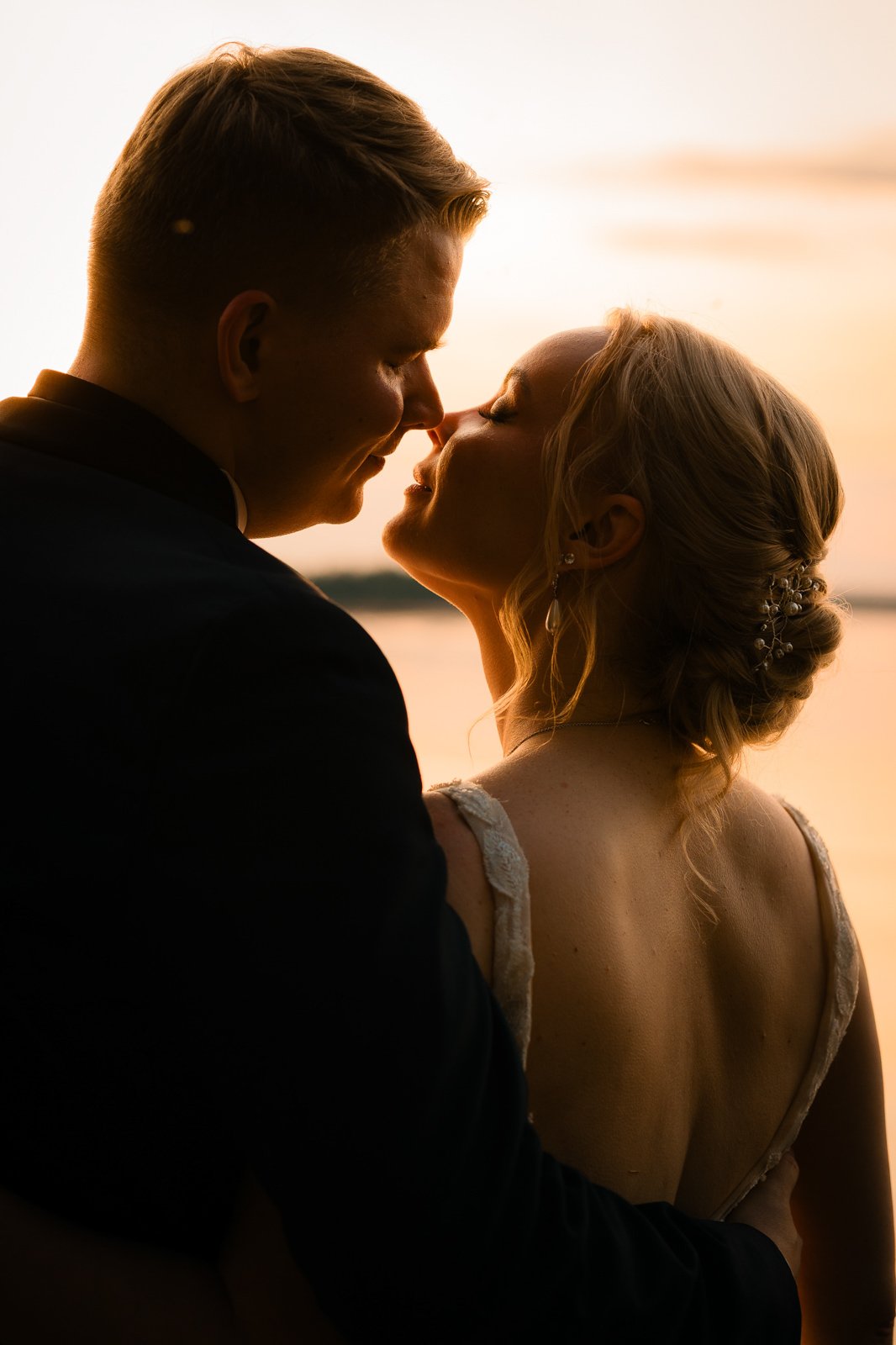 Lehmonjärjessä auringonlaskun aikaan otettu hääkuva.