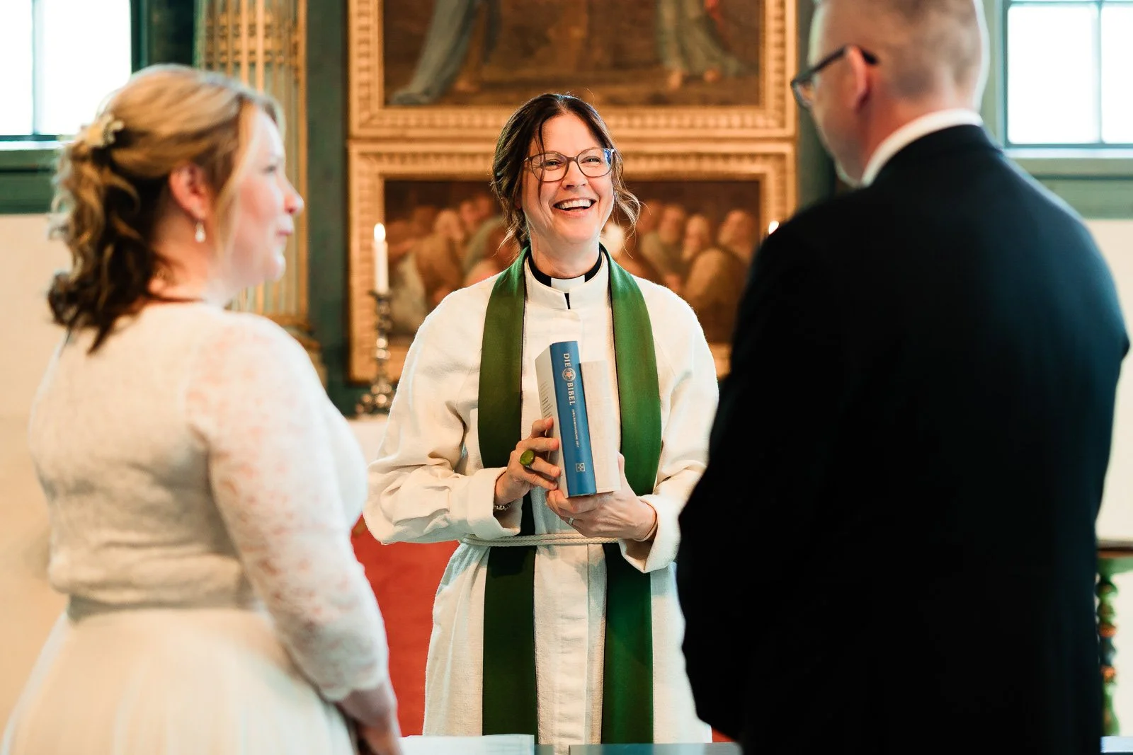 Vihkimisen valokuvaus, pappi vihkiraamattujen kanssa.