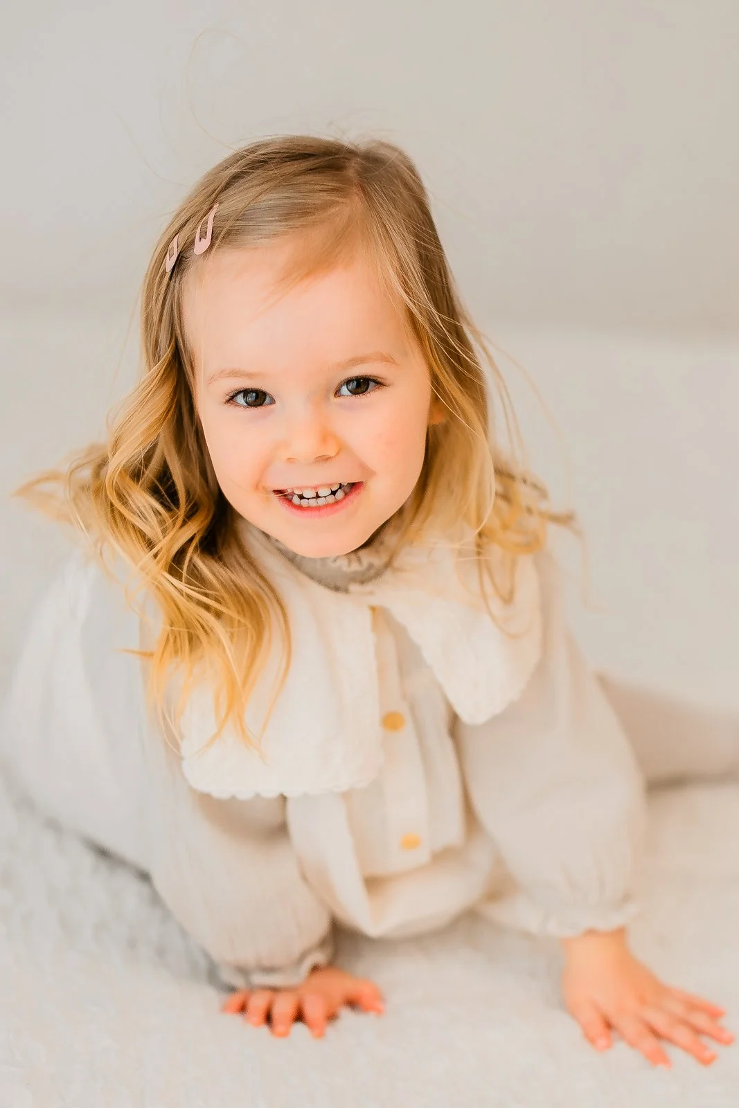 Lapsikuvaus studiolla Tampereella, 3-vuotias valkoisessa mekossa katsoo kameraan.