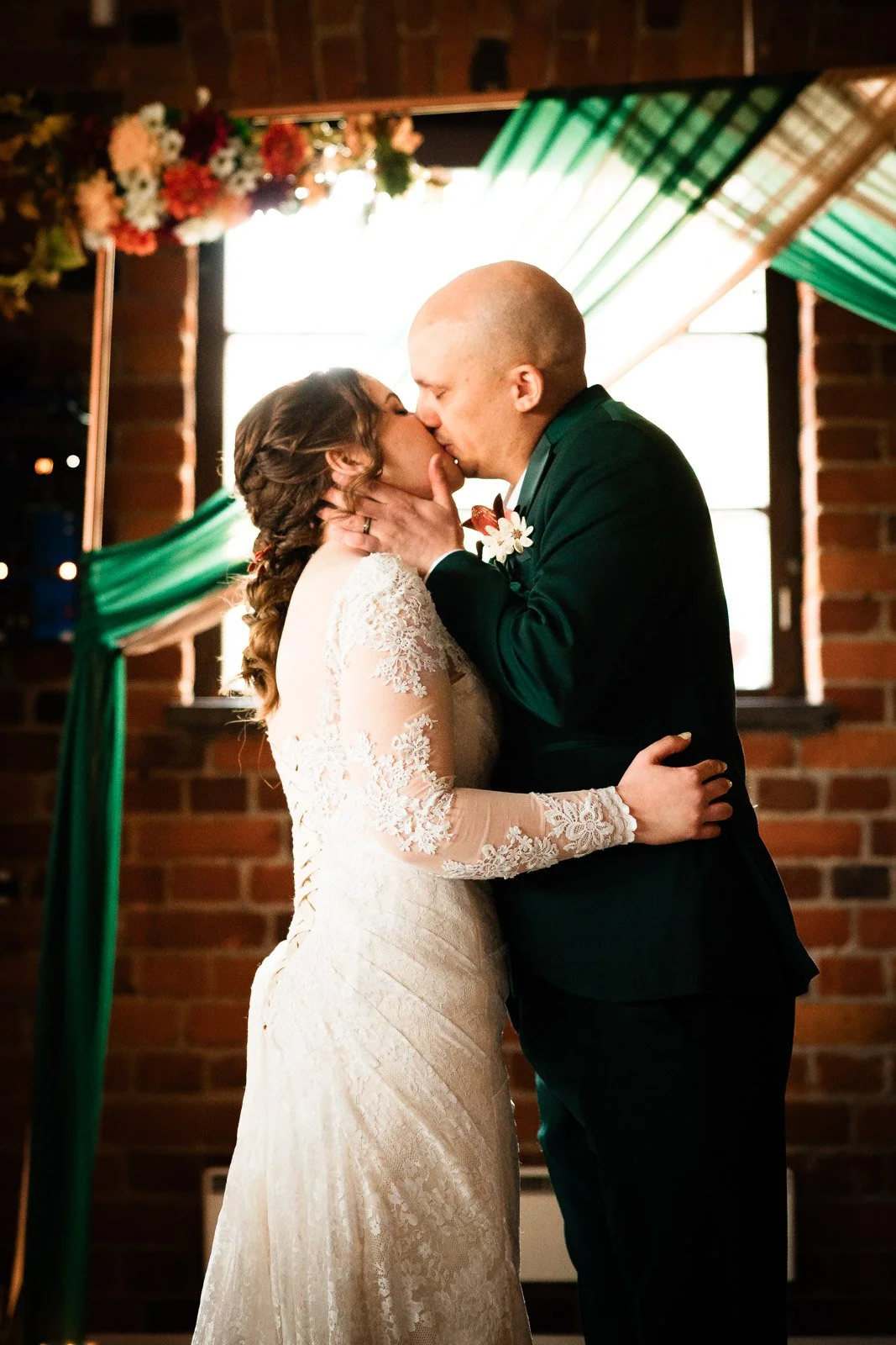 Hääkuvaus Tampereen vanhalla Haulitehtaalla, hääparin suudelma alttarilla.