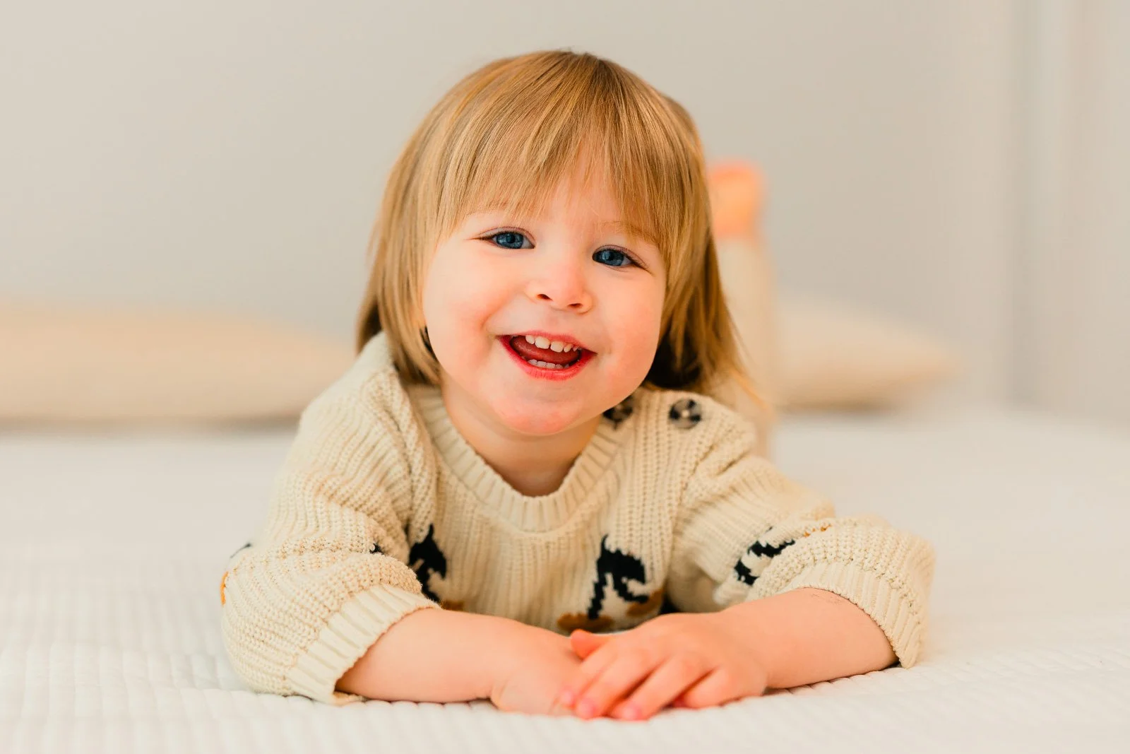 Lapsikuvaus studiolla Tampereella, 2-vuotias tyttö makaa sängyllä ja katsoo kameraan.