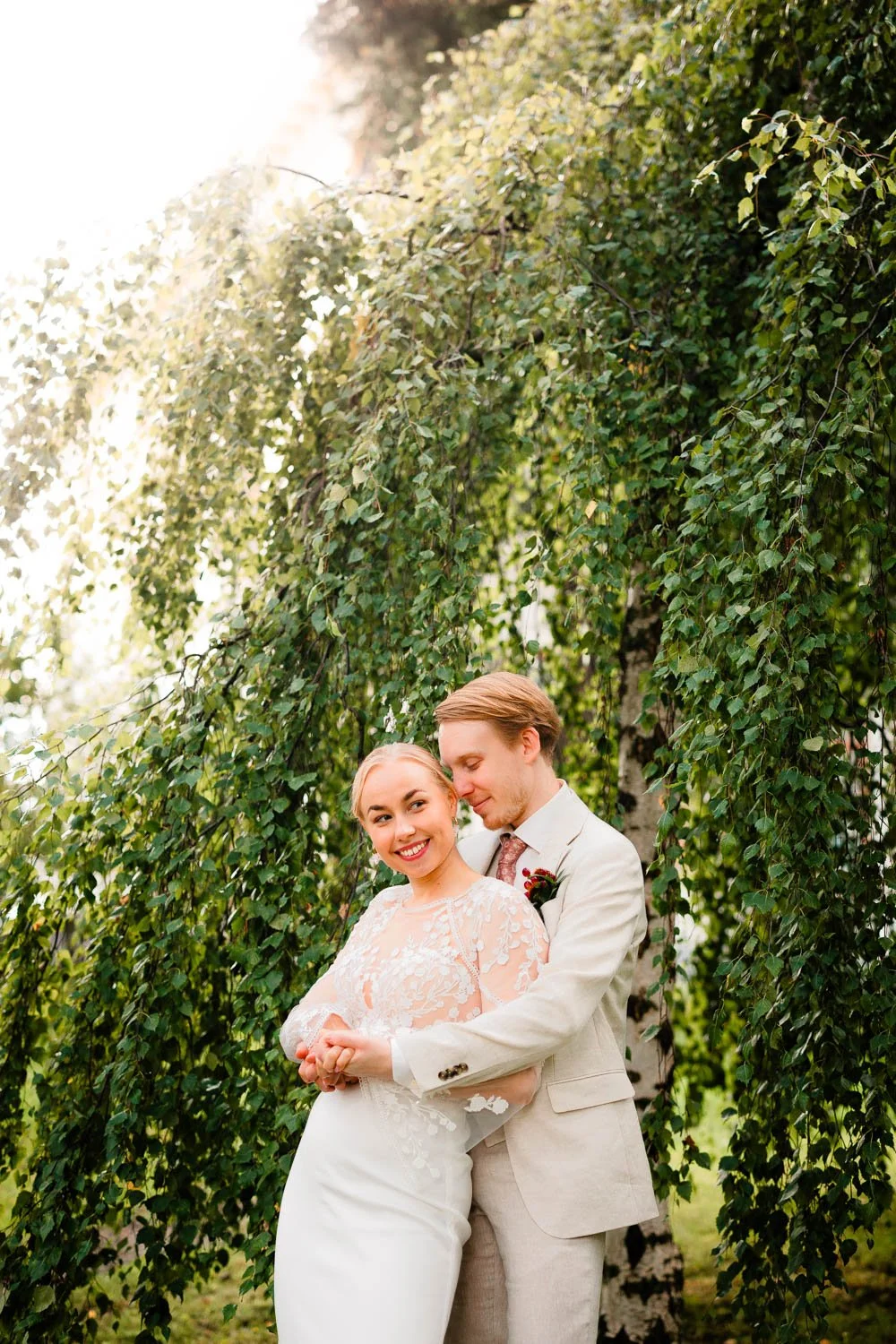 Häävalokuvaaja Tampere, hääpari vihreän koivun edessä.