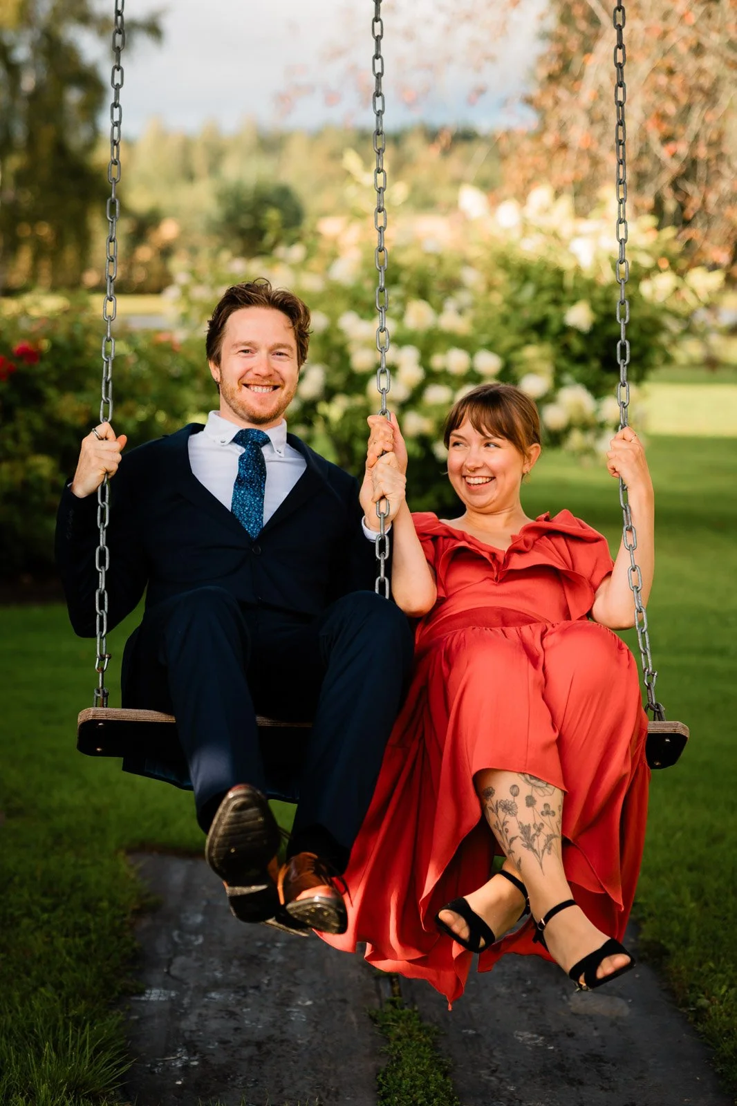 Dokumentaarinen hääkuvaus, häävieraat keinumassa juhlapaikan pihalla.