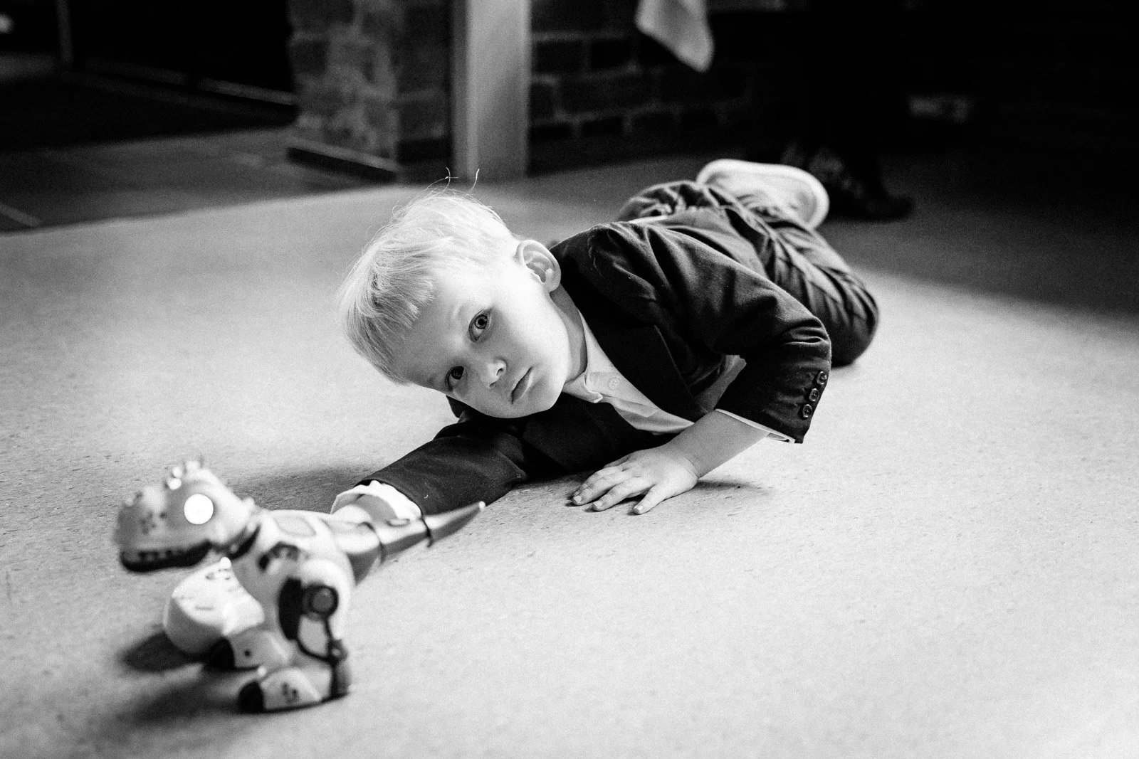 Dokumentaarinen hääkuva, lapsi lelun kanssa lattialla.