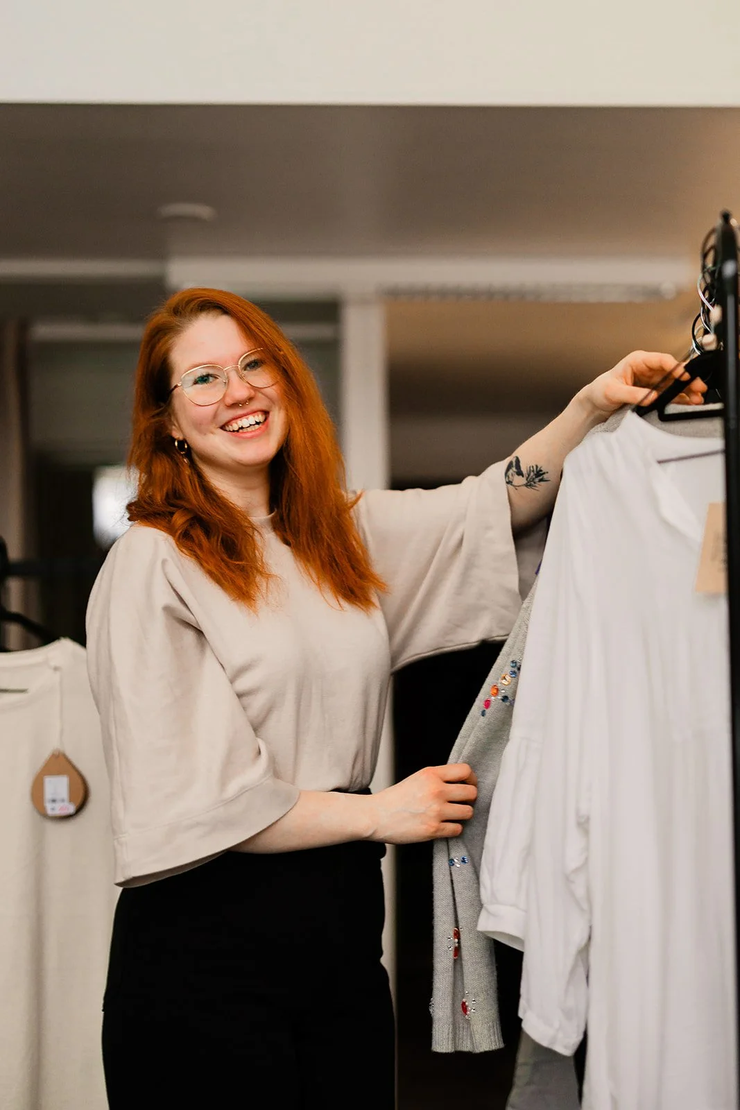 Yrityskuvaus Tampereella, second hand -kaupan myyjä asettelemassa tuotteita rekkiin.