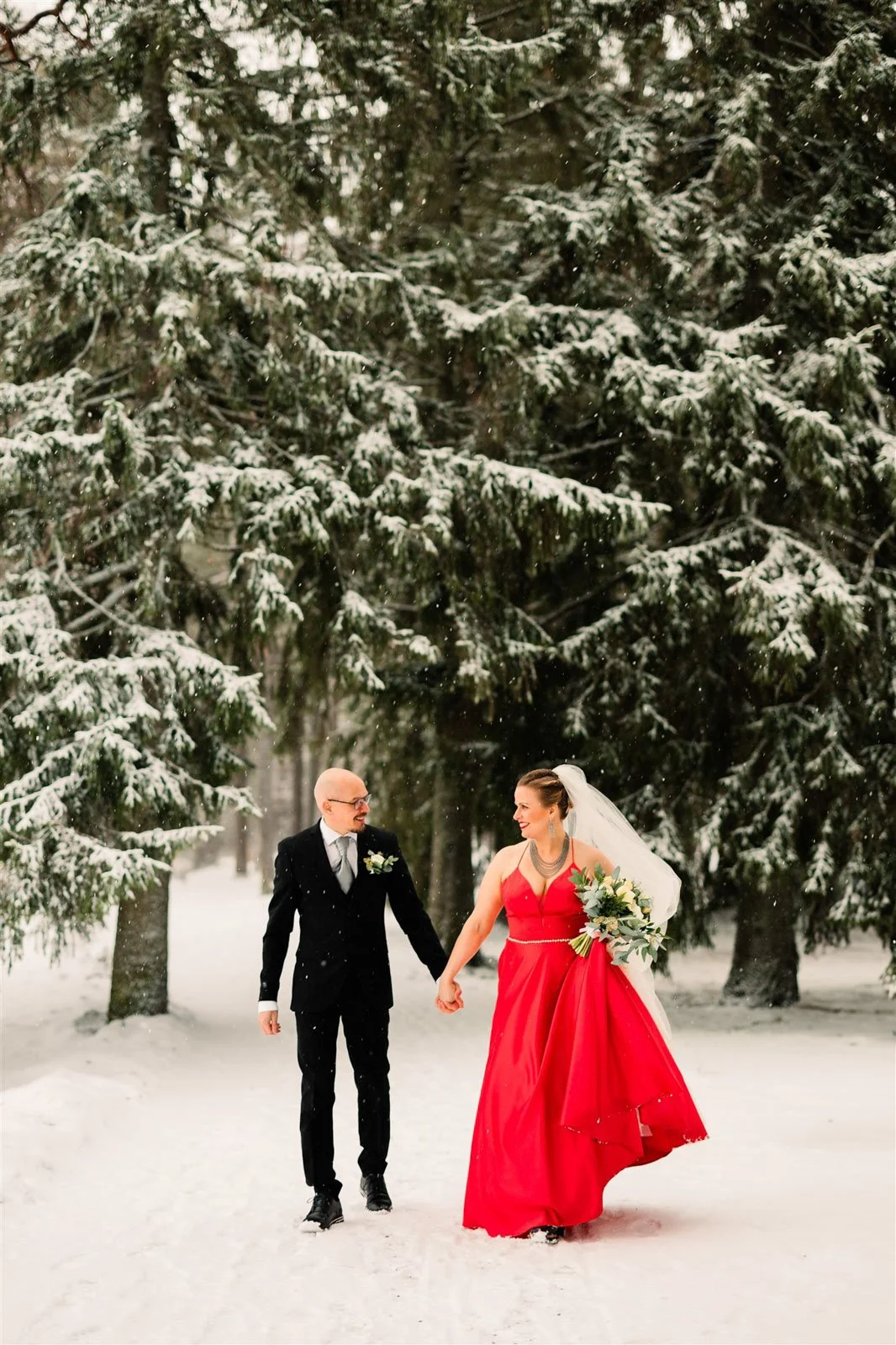 Häävalokuvaaja Tampere, hääpari kävelee kohti kameraa käsi kädessä, taustalla luminen maisema.