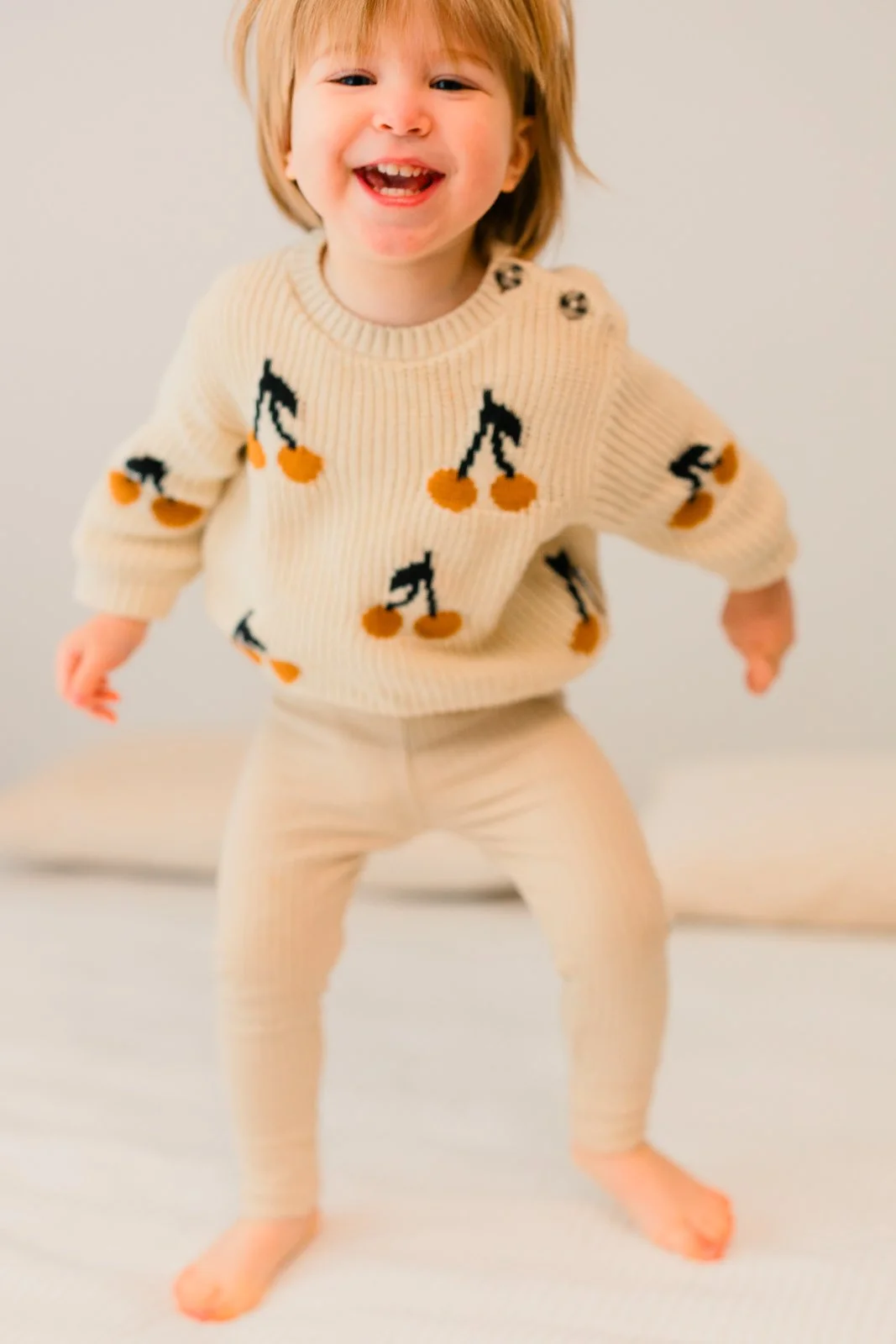 Lapsikuvaus studiolla Tampereella, 2-vuotias tyttyö hyppii sängyllä.